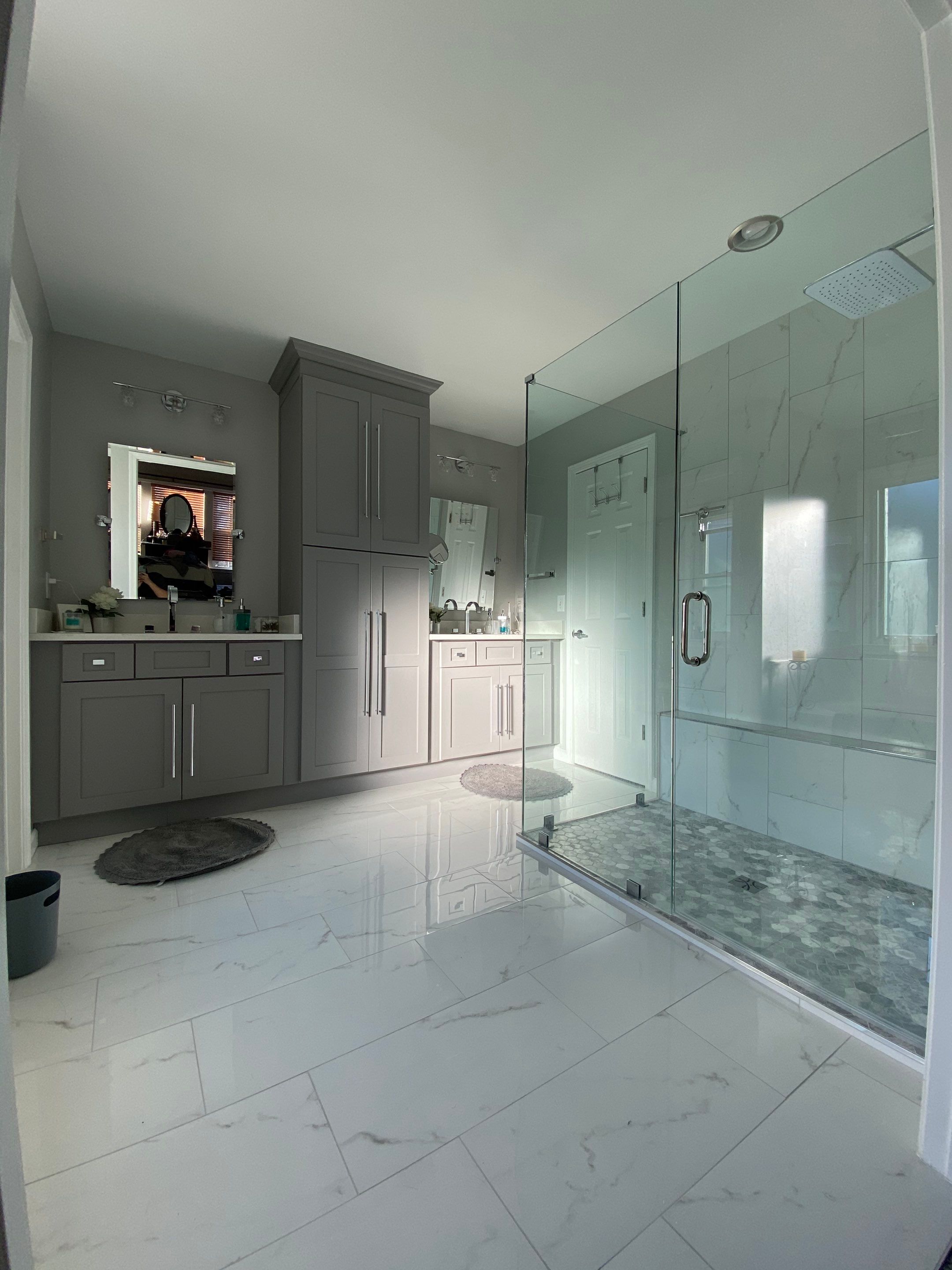 Master Bathroom Renovation Featuring Marble-Look Tile and Frameless Glass by Swift Home Renovations