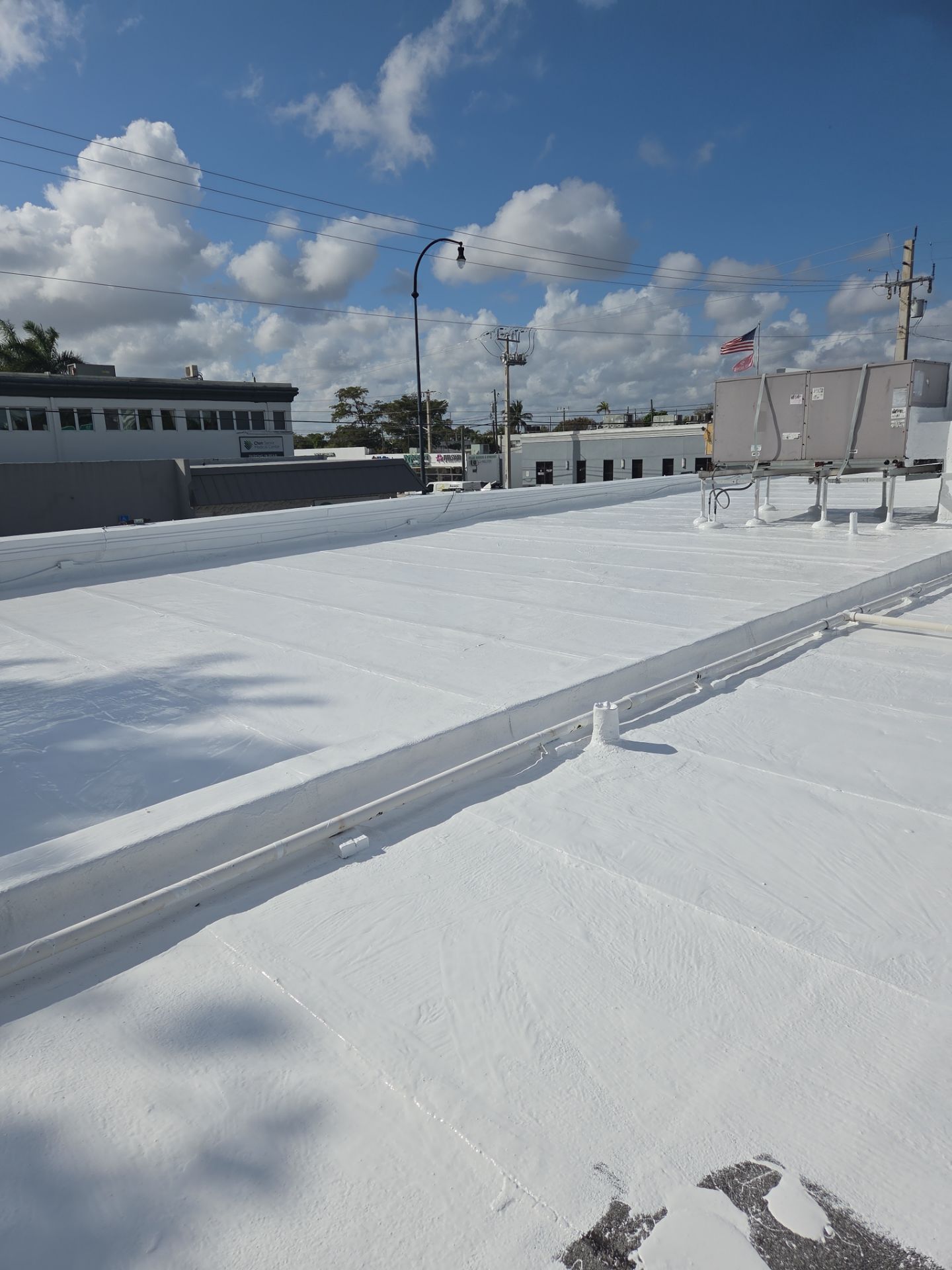 Commercial Flat Roof Restoration Using Silicone Coating in Hallandale Beach by Aastro Roofing