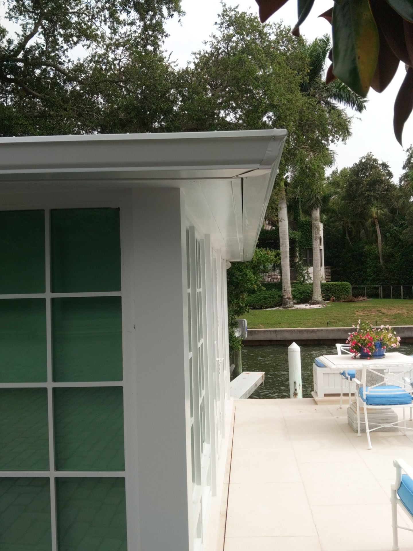 Seamless aluminum gutter installation in Sarasota, FL using 3x4 elbow downspouts combined with round downspouts by Gutter Professors