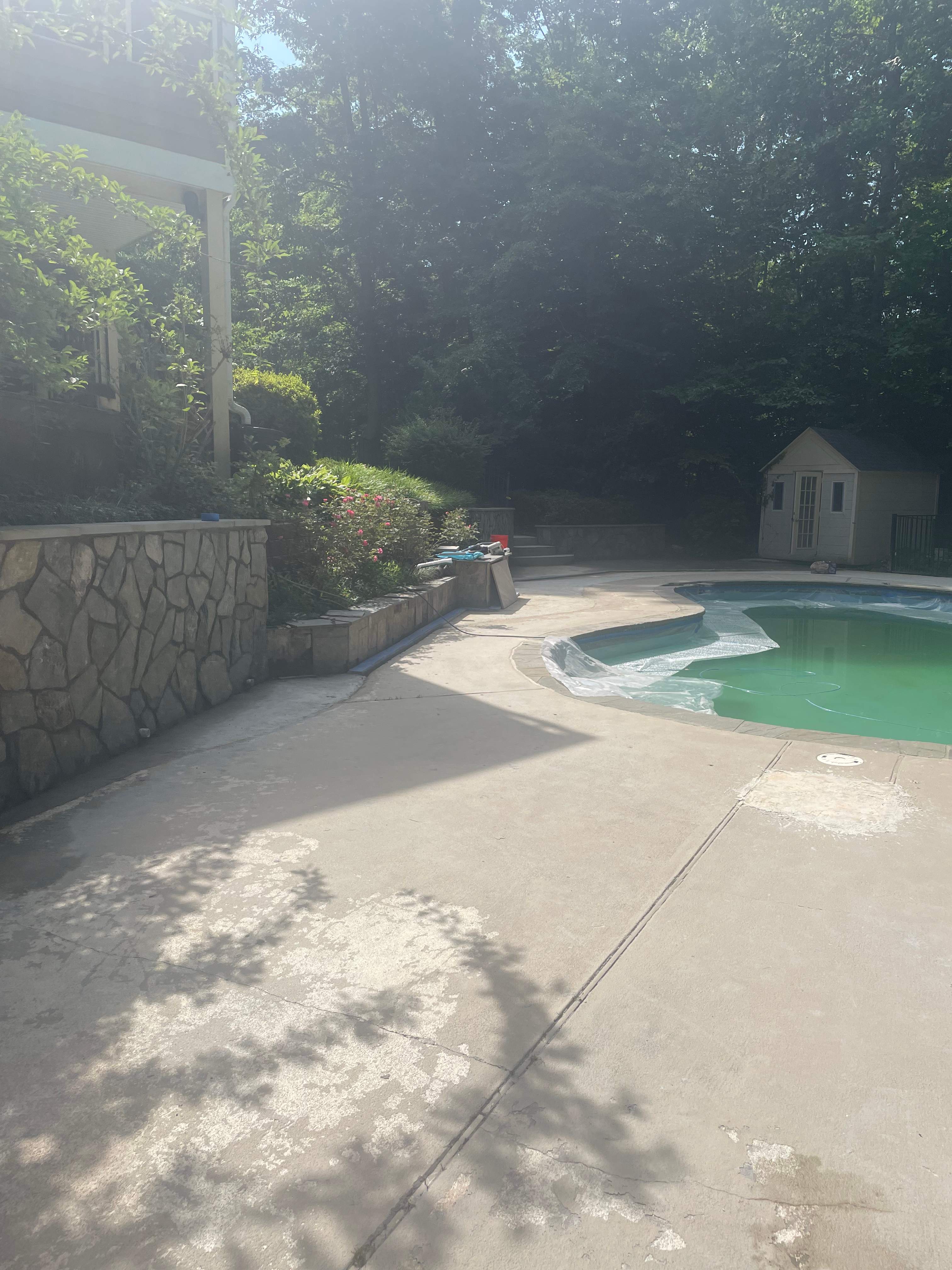 Pool Surround remodel with retaining walls, new waterfall and water slide by Fairfax Contractors, LLC