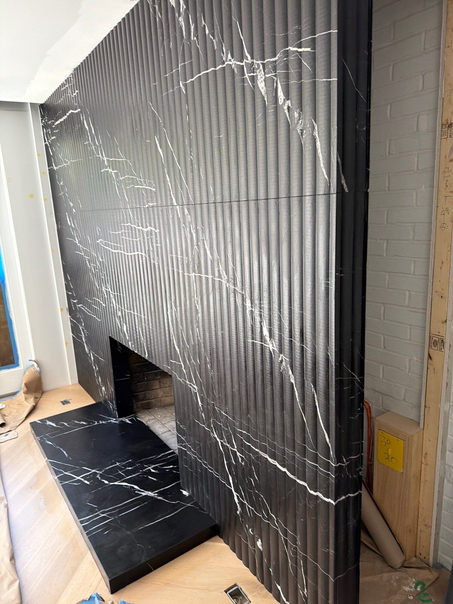 Full-Height Fluted Marble Fireplace Wall by NC Stone And Tiles