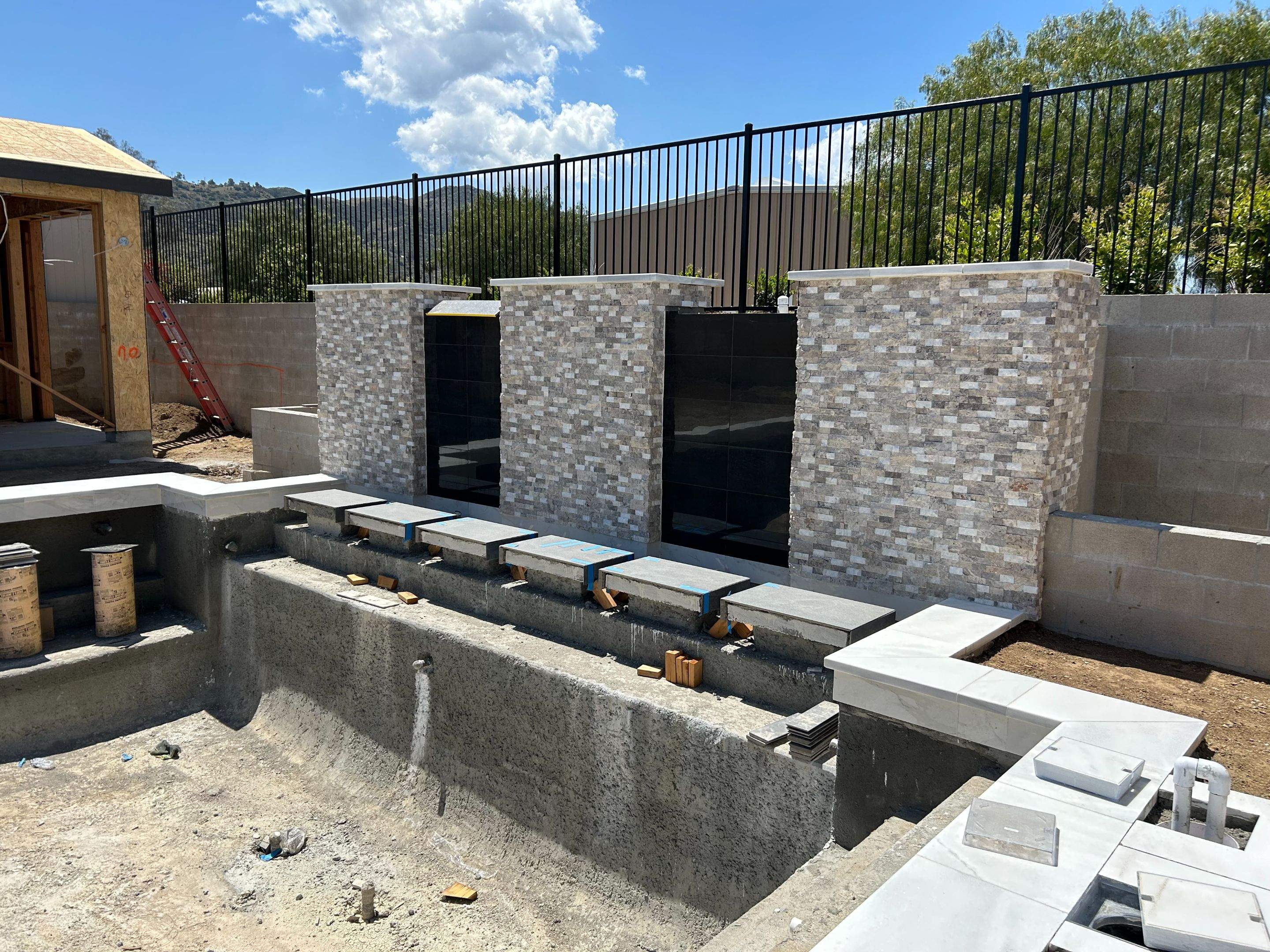 Pool spa zero edge spa, large water wall, floating steps, bar stools by Premier Pools and Spas Temecula