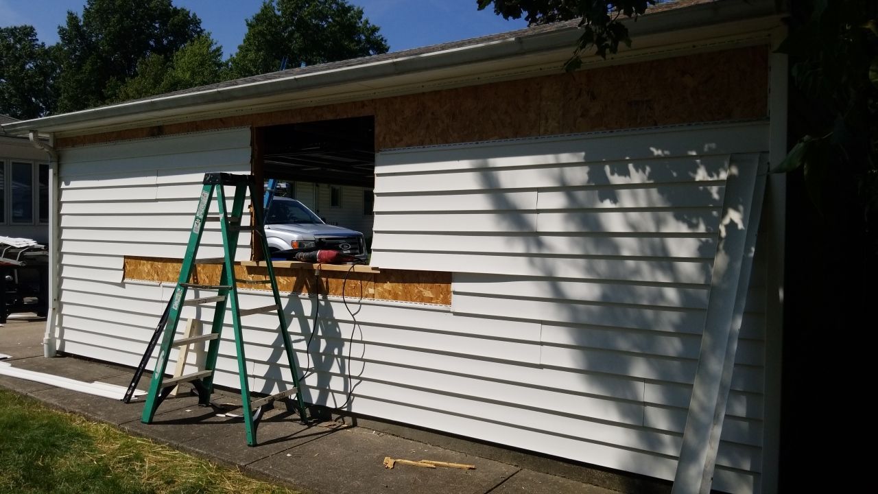 Siding Installation using Norandex woodsman dl-5 white woodgrain vinyl by Absolute Roofing and Construction