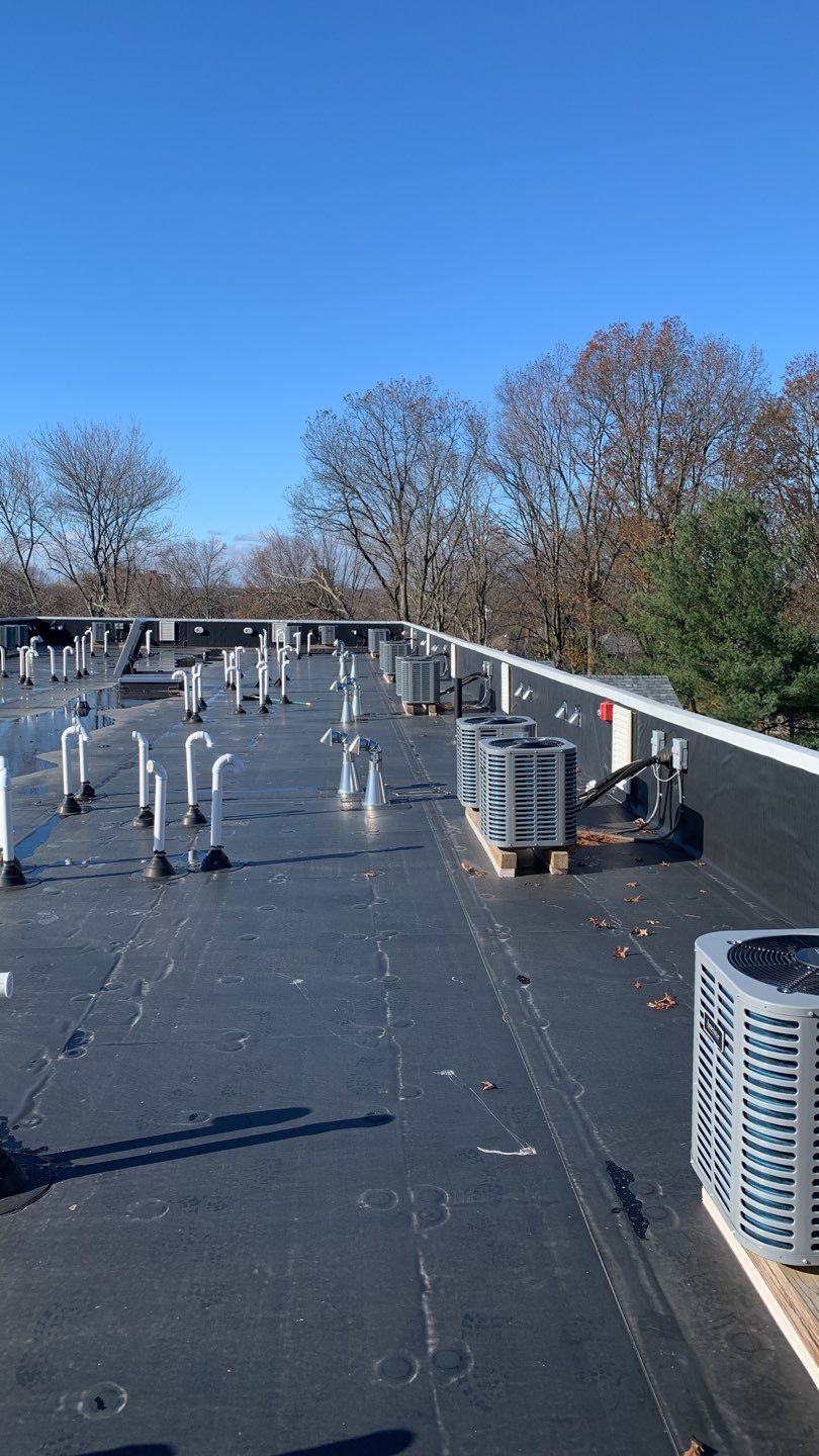 Commercial Roofing Installation using EPDM with white gutters by A Plus Exterior