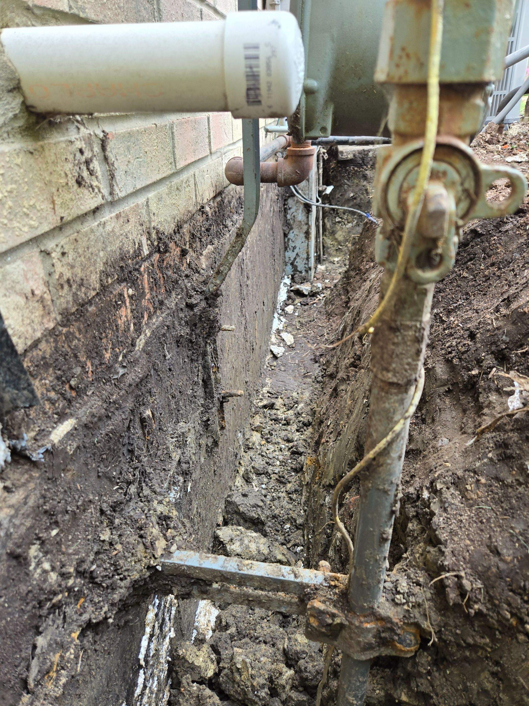 Burial of Sump Pump and Down Spout Discharges and Partial Waterproofing of Wall by Allied Water Services