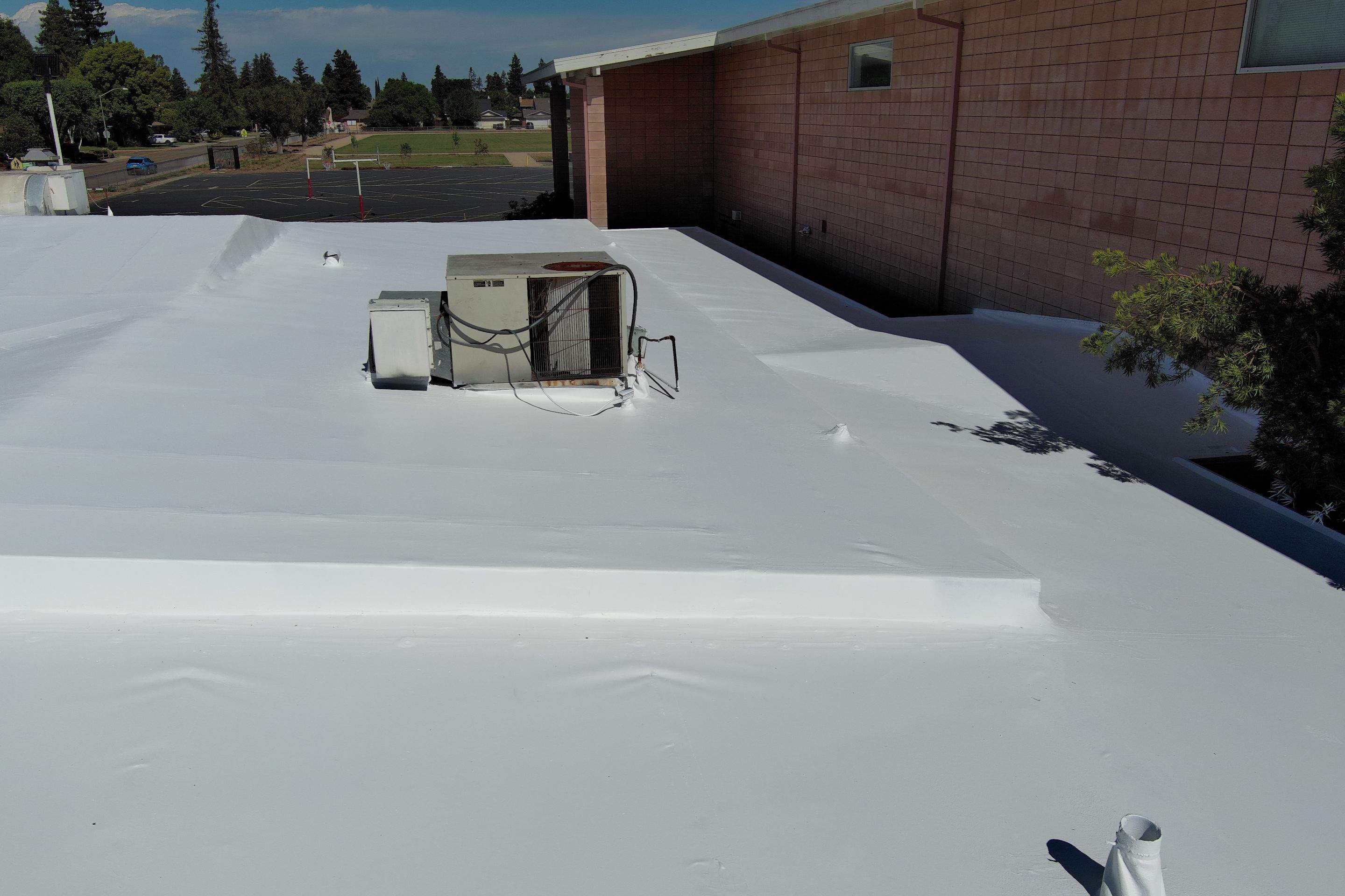 Single-ply restoration system using Benchmark/PUMA XL coatings over TPO single-ply roofing by Straight Edge Roofing Inc