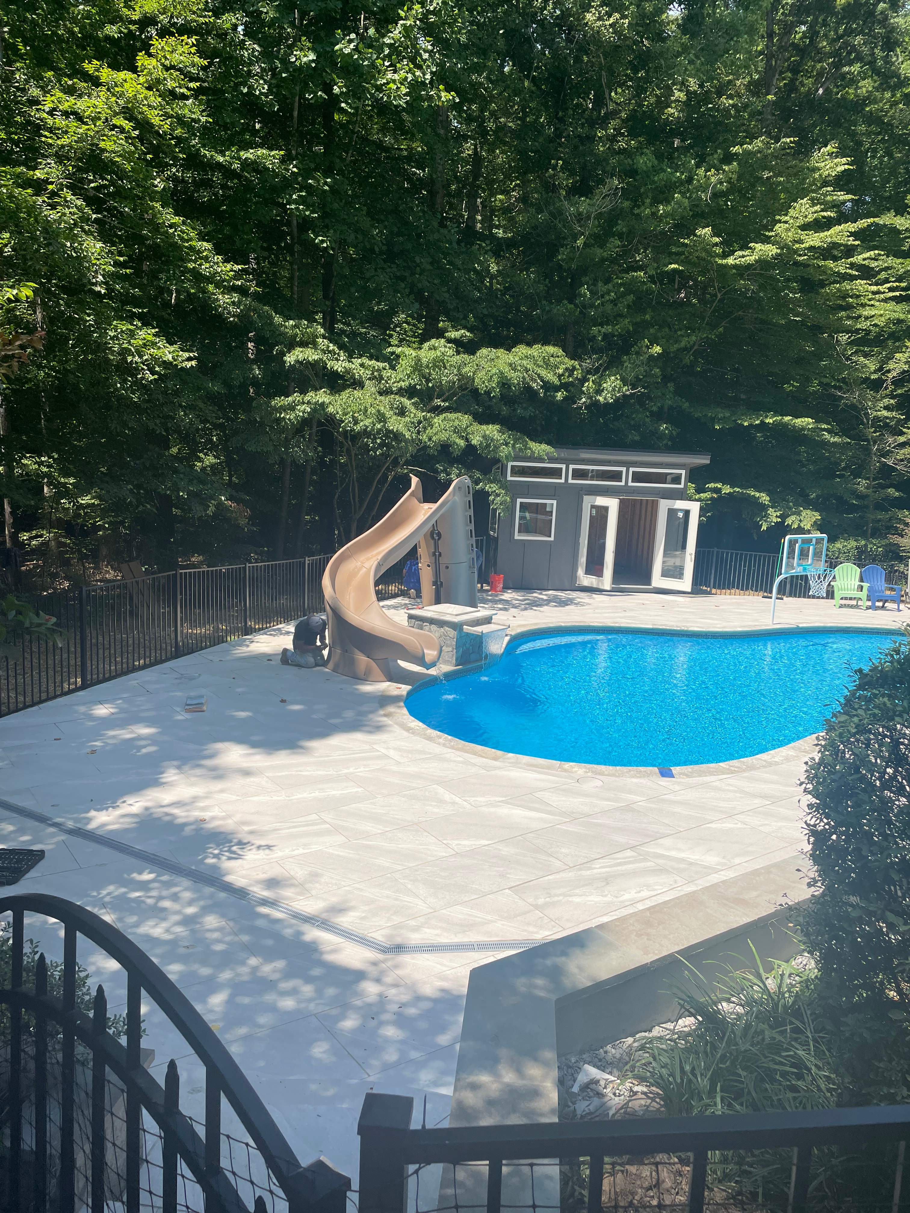 Pool Surround remodel with retaining walls, new waterfall and water slide by Fairfax Contractors, LLC