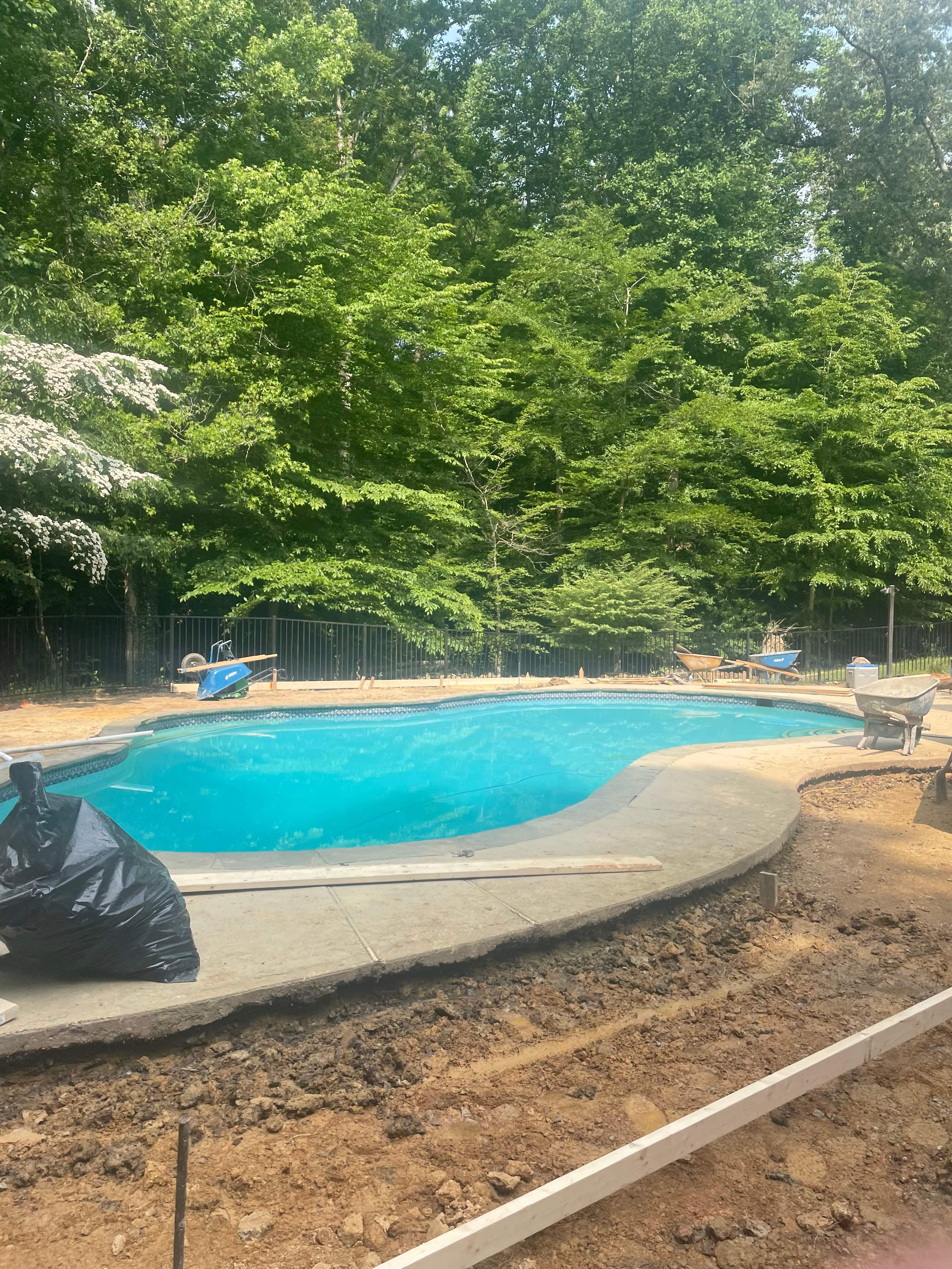 Pool Surround remodel with retaining walls, new waterfall and water slide by Fairfax Contractors, LLC