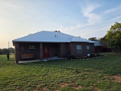 Completed metal roof on a brick home, front view.