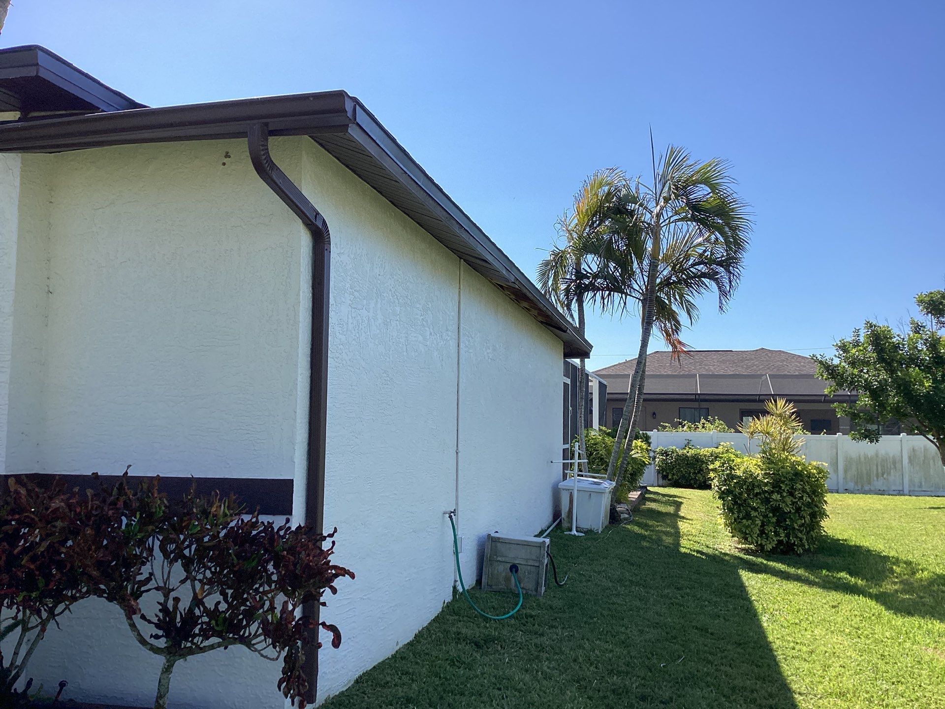 Brown Gutter + White and Brown Downspouts in Cape Coral FL by Gutter Professors