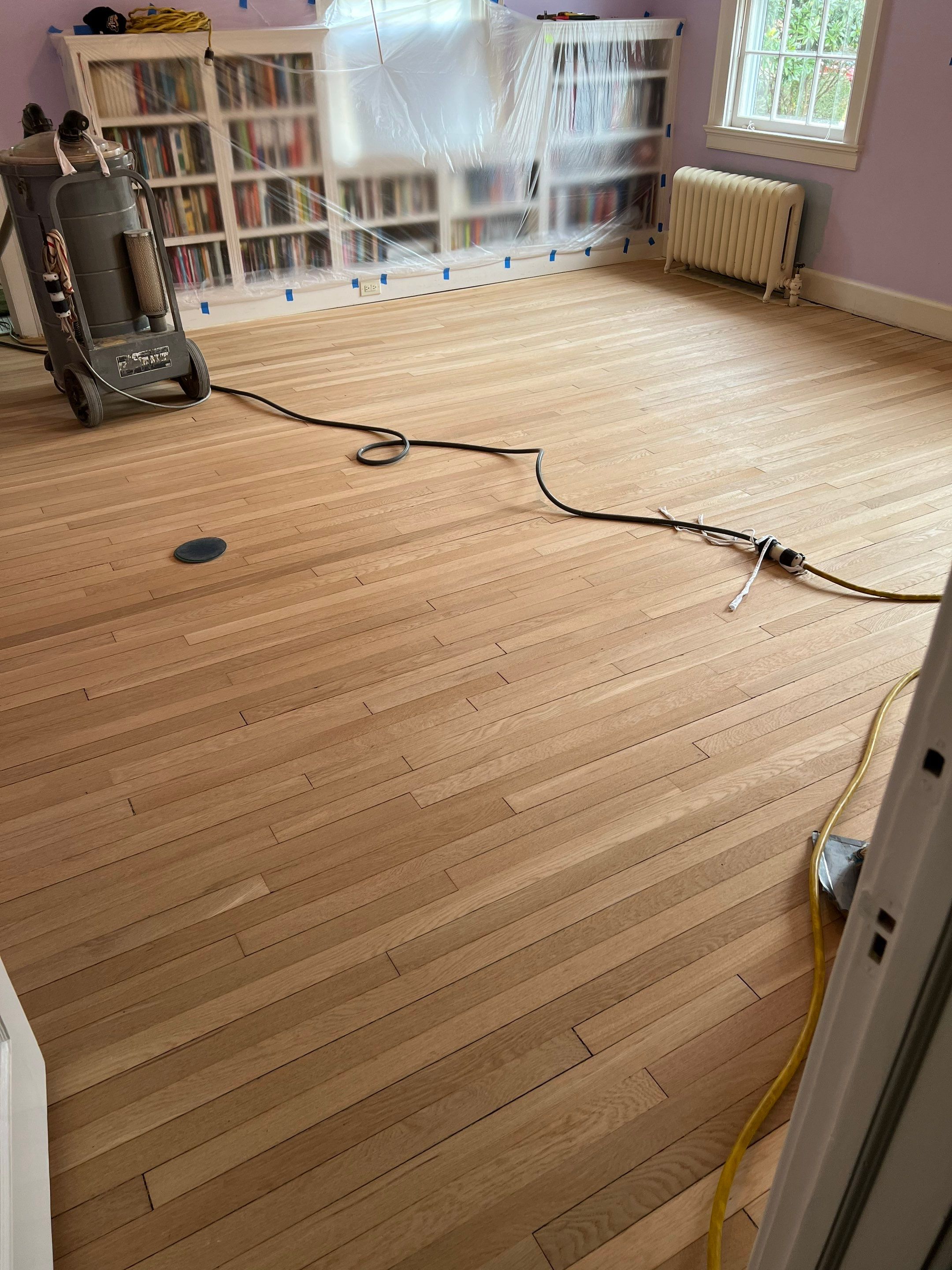 Two bedrooms with hardwood under carpet by Accent Custom Floors