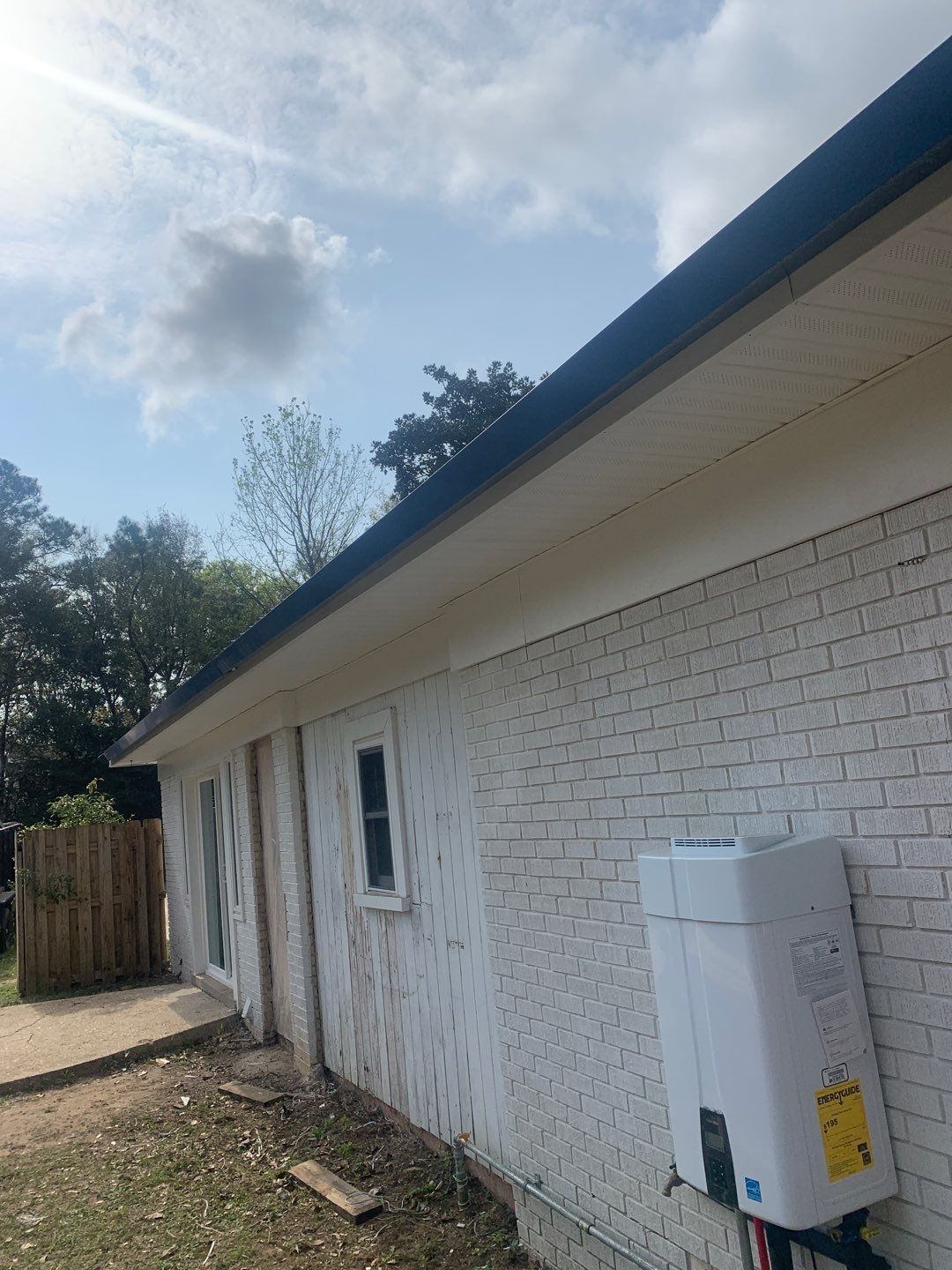 White Seamless Gutters and Black Downspouts by Gutter Professors