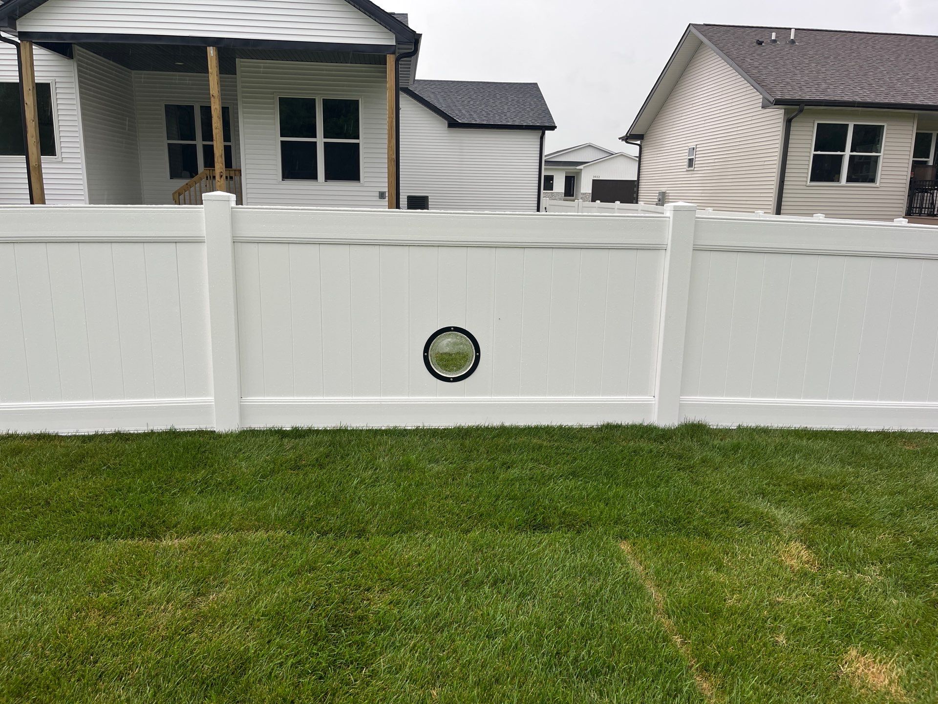White Vinyl Privacy Fence With Pet Window in Cedar Falls by Perfect Picket Fence and Stain