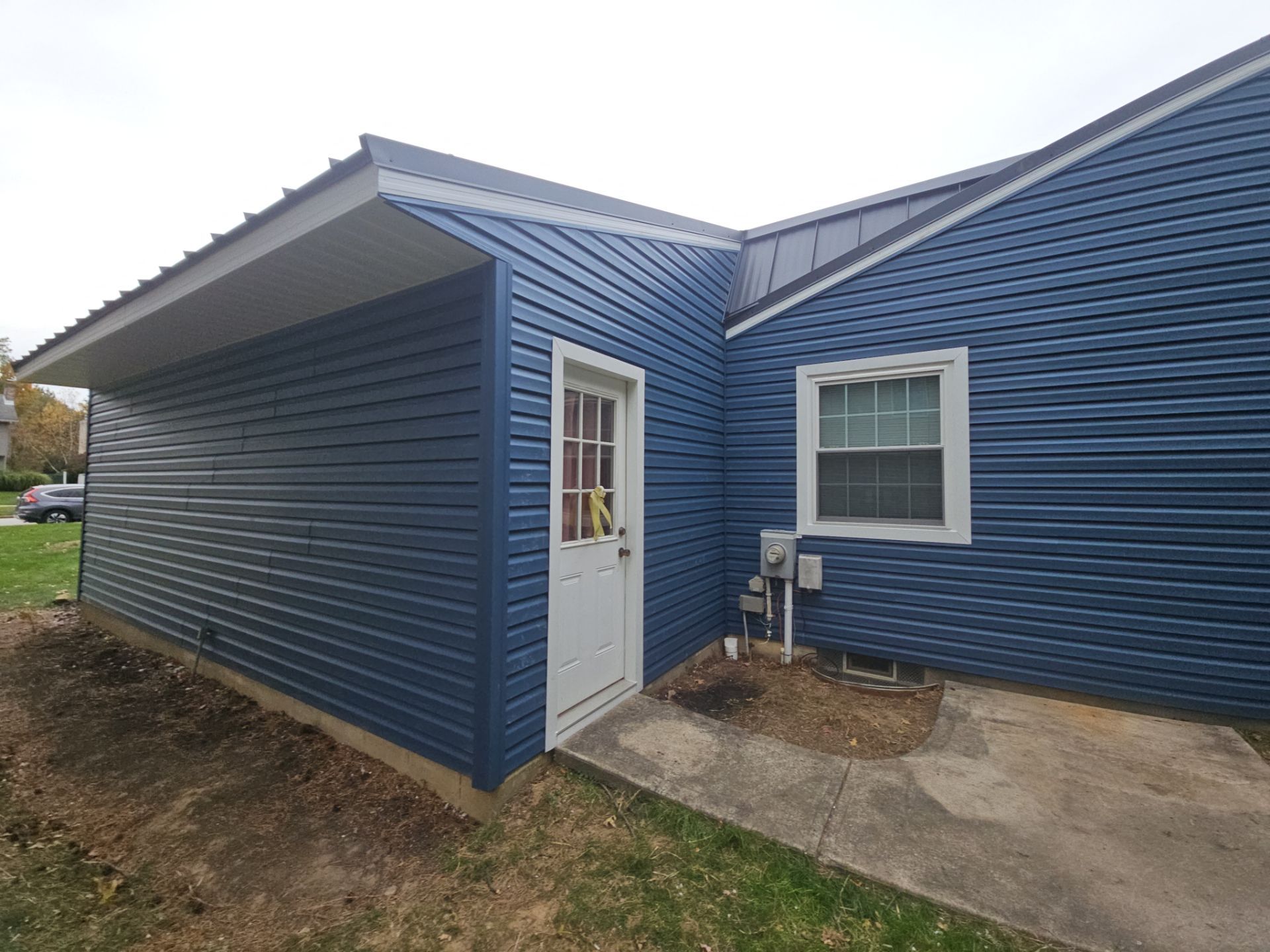 Wadsworth Exterior Transformation Featuring Blue Vertical Siding and Metal Roofing by Cornerstone Roofing And Siding