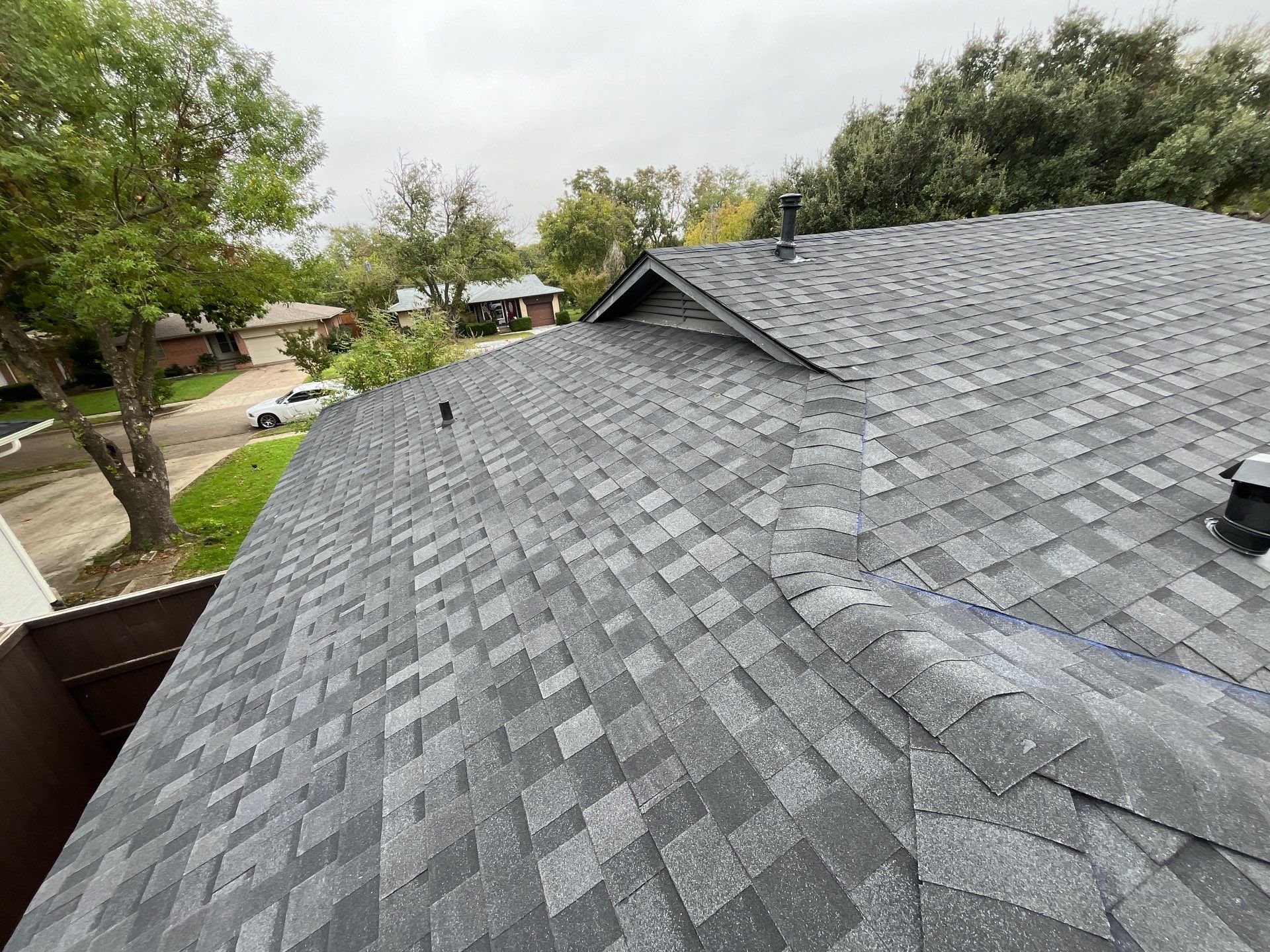 White brick/black accents with IKO Granite Black by Tejas Roofworks + Restoration
