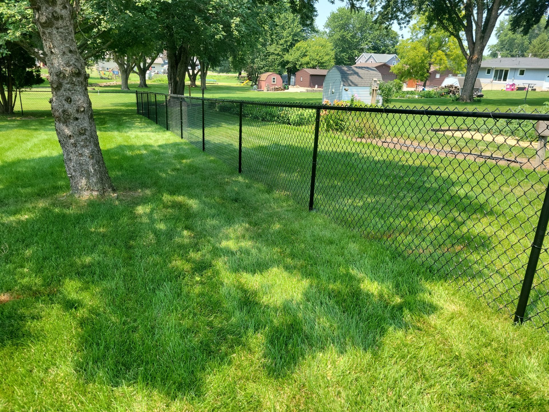 Black Vinyl-Coated Chain Link Fence Installation in New Hampton by Perfect Picket Fence and Stain