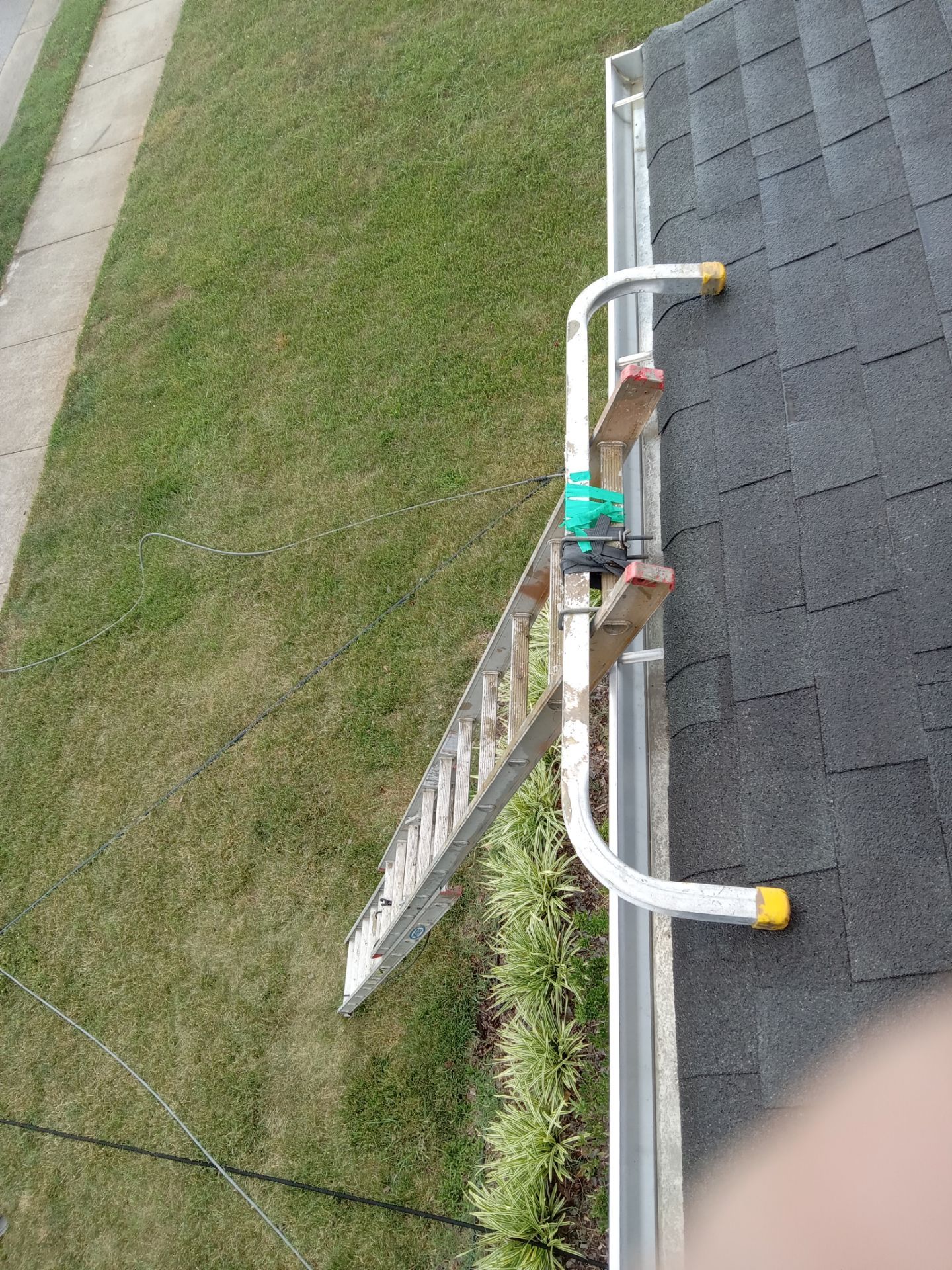 pressure washing company cleaning gutters and possibly the roof surface on a residential home