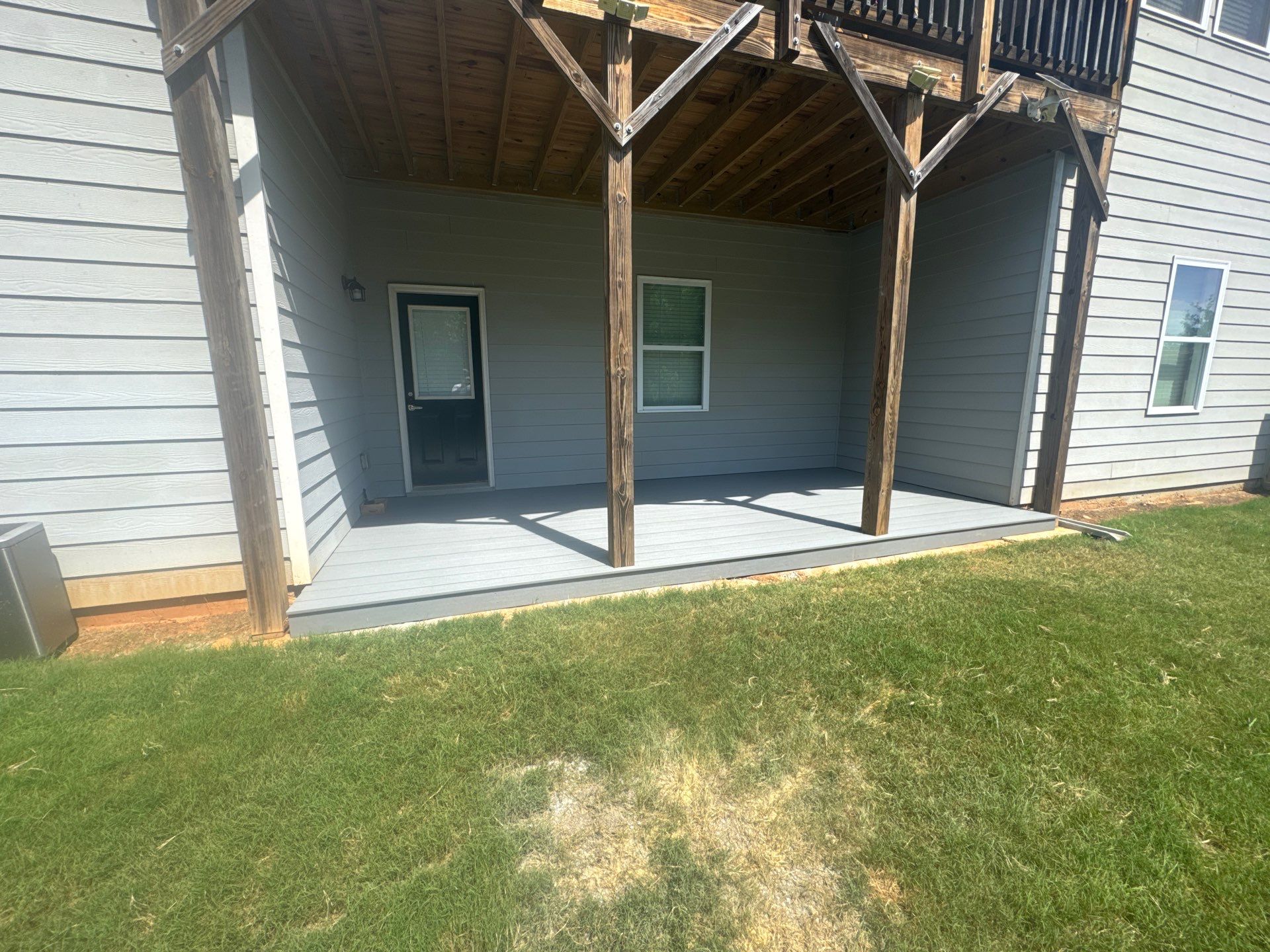 Ground-Level Gray Composite Deck and Privacy Fence Installation by Swift Home Renovations
