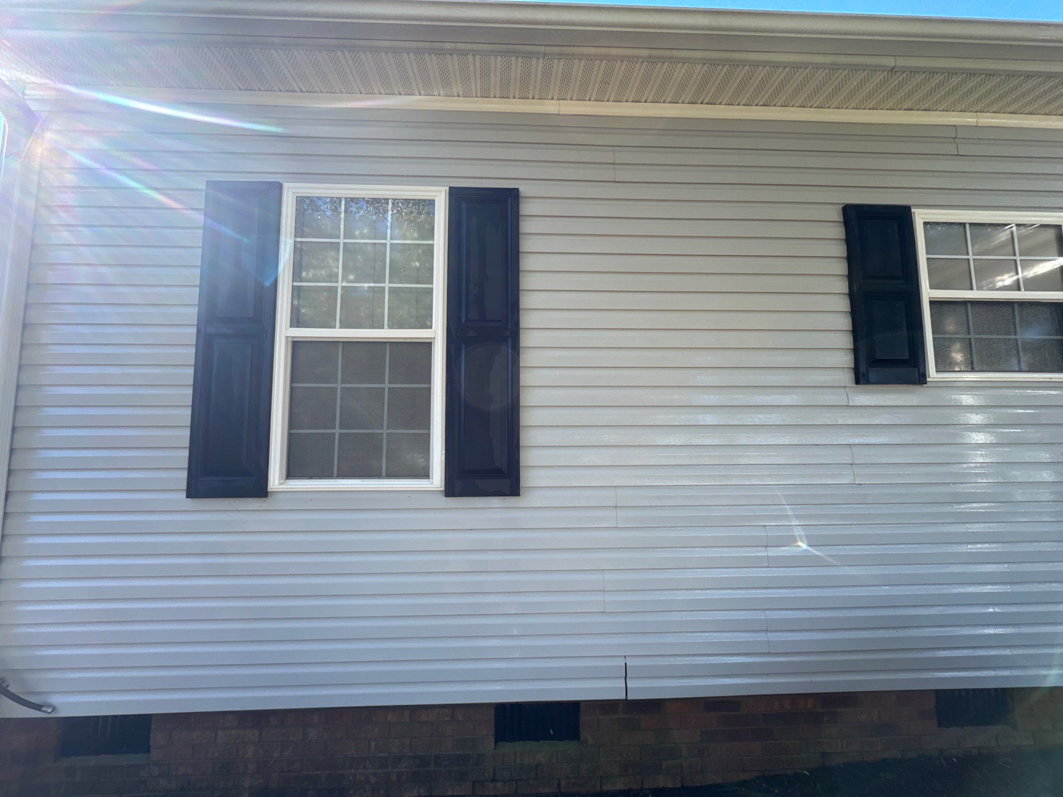 the service shown is house washing focusing on cleaning vinyl siding and windows to remove dirt and grime