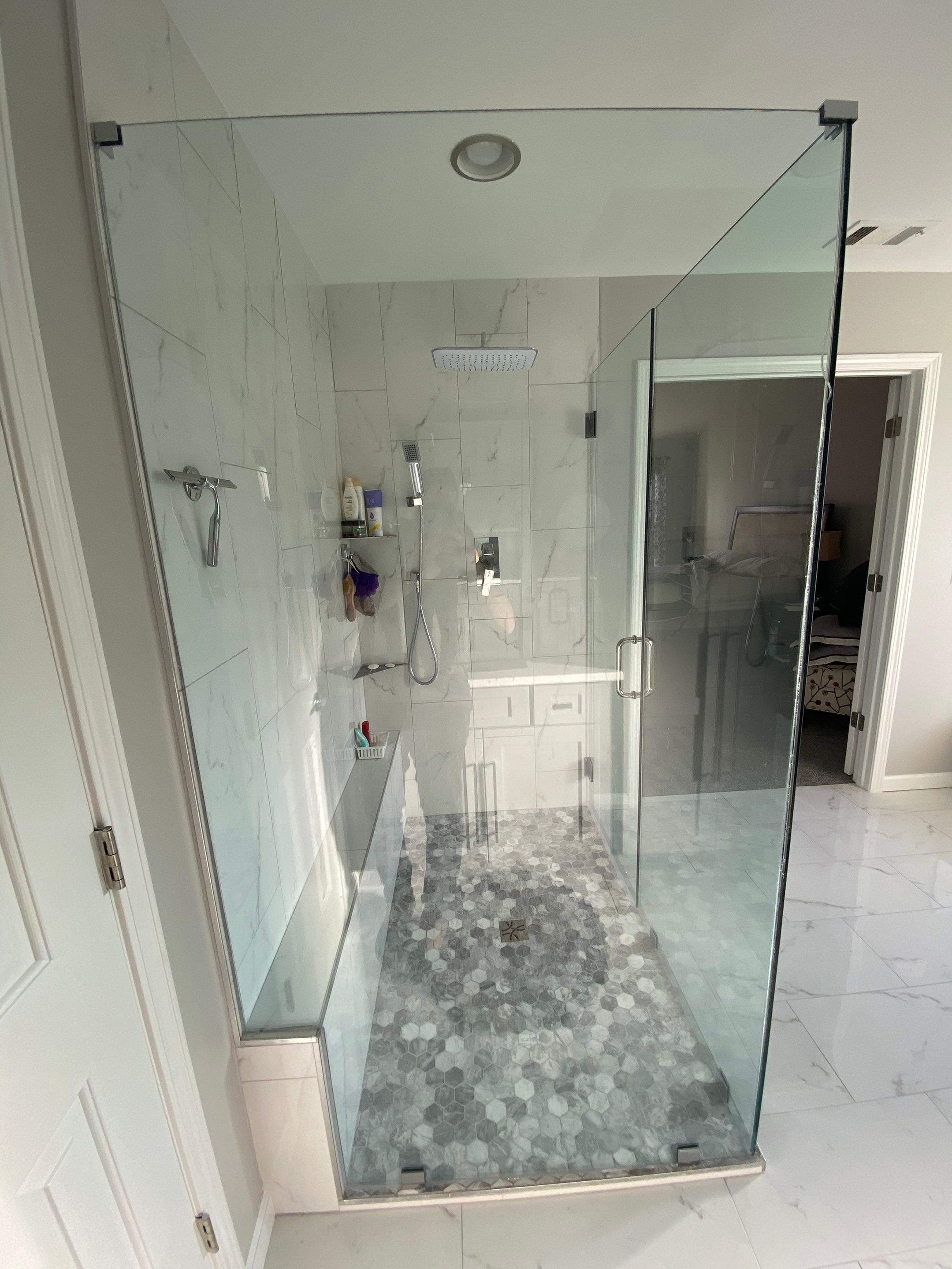 Master Bathroom Renovation Featuring Marble-Look Tile and Frameless Glass by Swift Home Renovations
