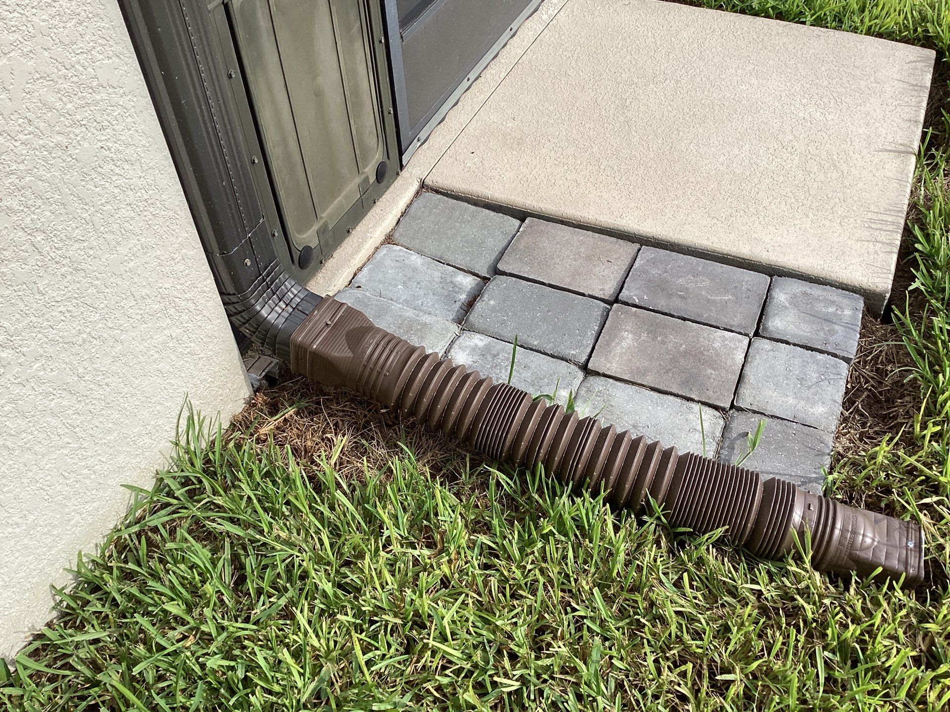 Musket brown seamless gutters with splash guards, new downspouts, and extensions in Bradenton, FL by Gutter Professors