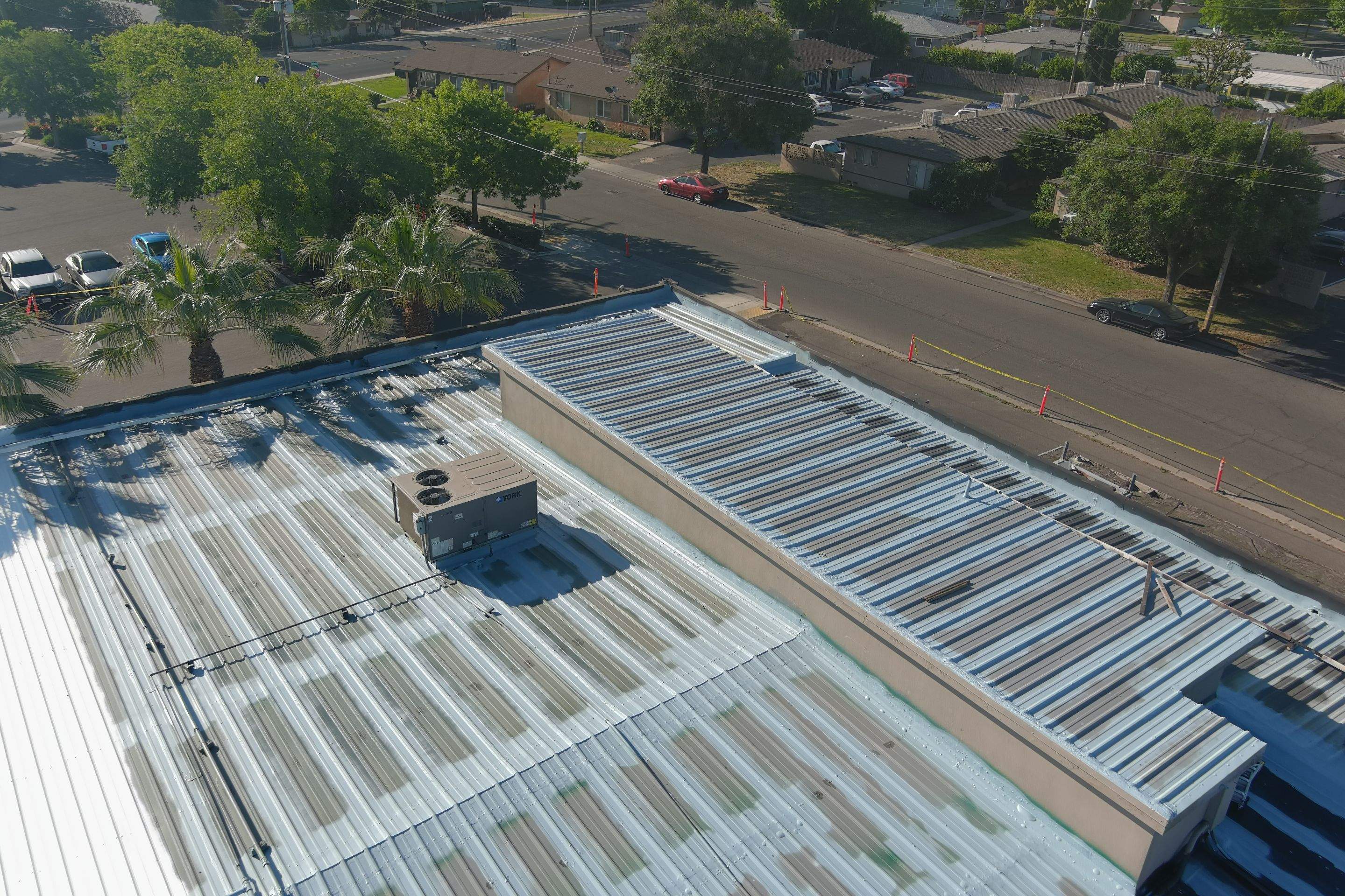 Metal roof restoration on commercial roof using Conklin Benchmark/ PUMA XL acrylic coatings over metal and foam by Straight Edge Roofing Inc