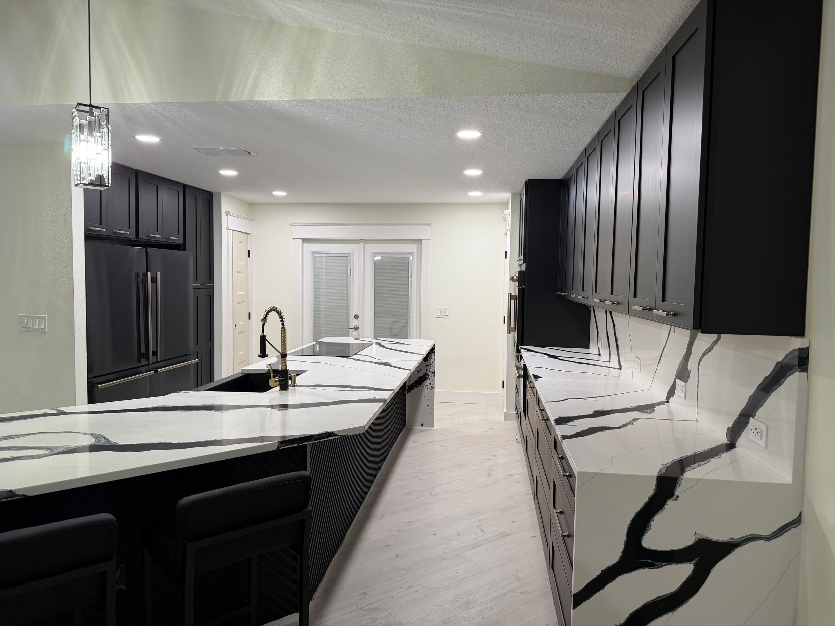 Modern Kitchen Remodel in Port Orange Featuring Waterfall Quartz Island by Acies Renovations