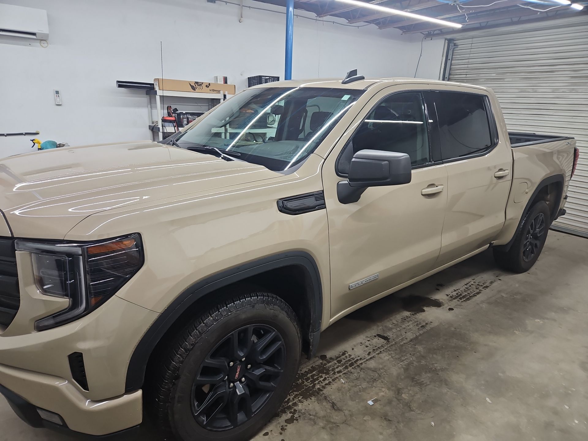 the image shows a light colored pickup truck which is being prepared for window tinting the service involves applying a thin film to the windows of the vehicle to reduce glare and heat while enhancing privacy the truck has dark wheels and appears to be in a clean and organized space suggesting a professional tinting job is taking place the process will likely improve the vehicle's appearance and comfort for the owner