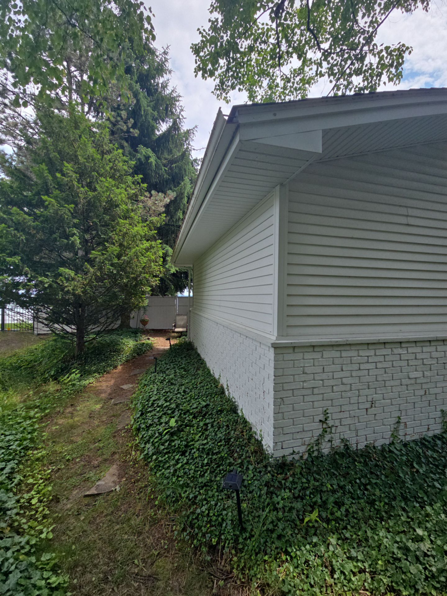 Black Gutter and Gutter Helmet Installation for Suttons Bay Home by Rainbow Seamless Systems