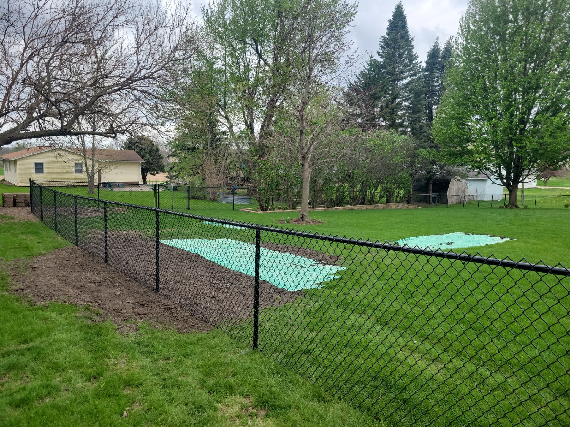 Residential Black Vinyl-Coated Chain Link Perimeter Fence in Garwin by Perfect Picket Fence and Stain