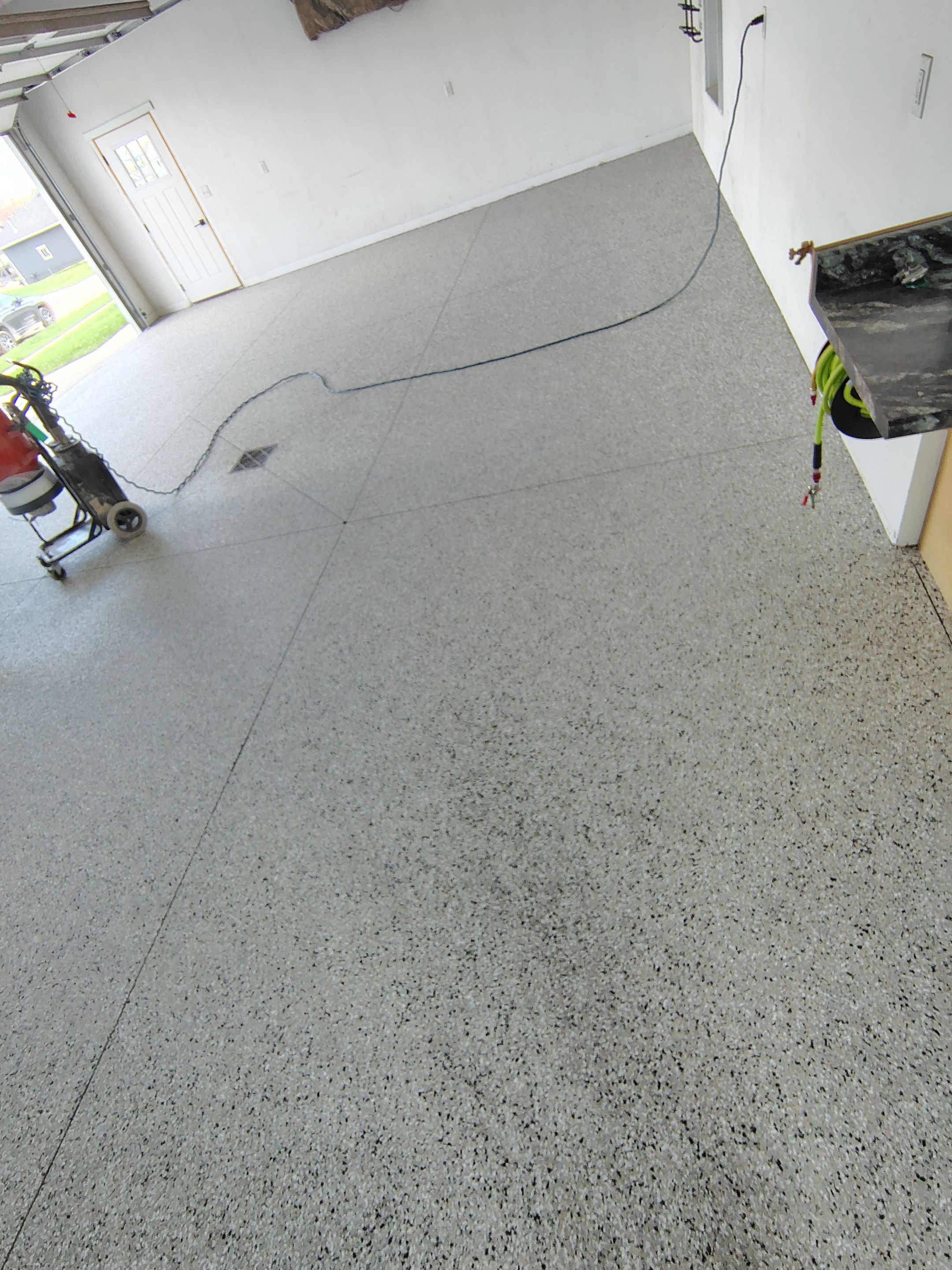 Speckled Polyaspartic Garage Floor Coating Installation in Dell Rapids by Select Painting, Coatings & Garage Cabinets