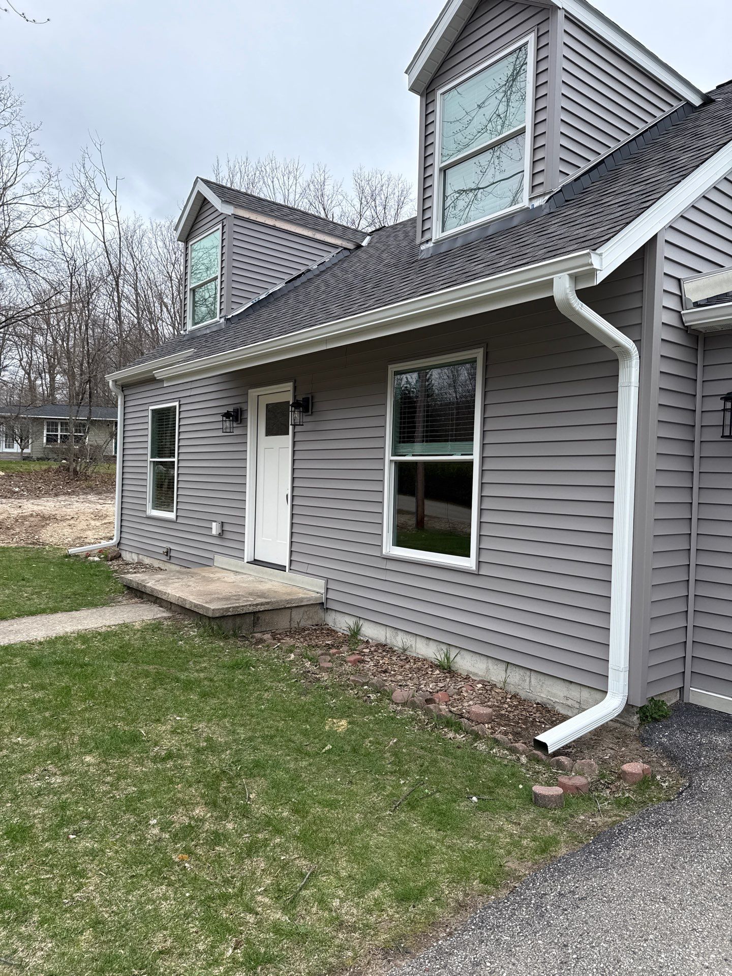 White Seamless Gutter and Downspout Installation in Charlevoix by Rainbow Seamless Systems
