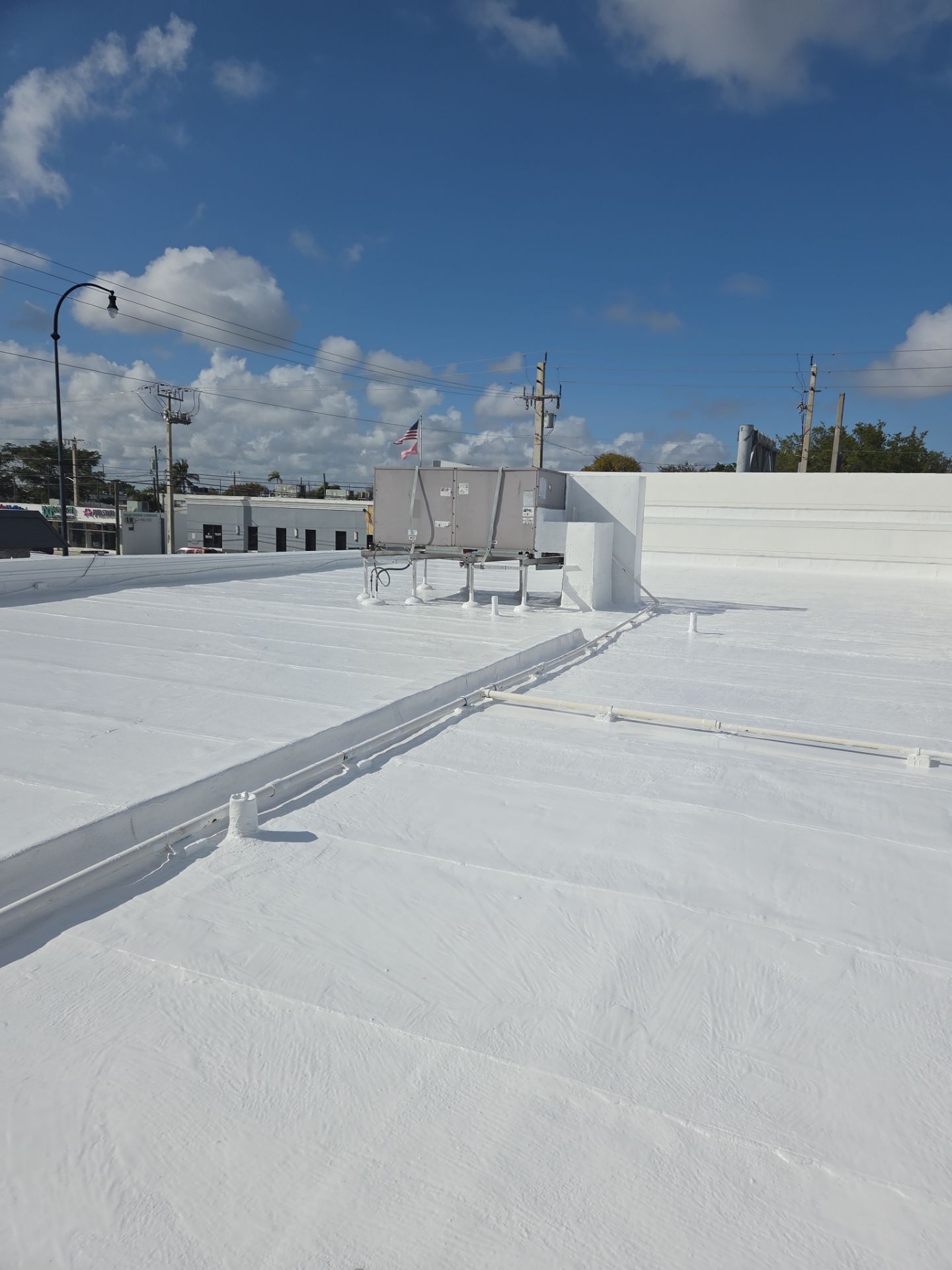 Commercial Flat Roof Restoration Using Silicone Coating in Hallandale Beach by Aastro Roofing