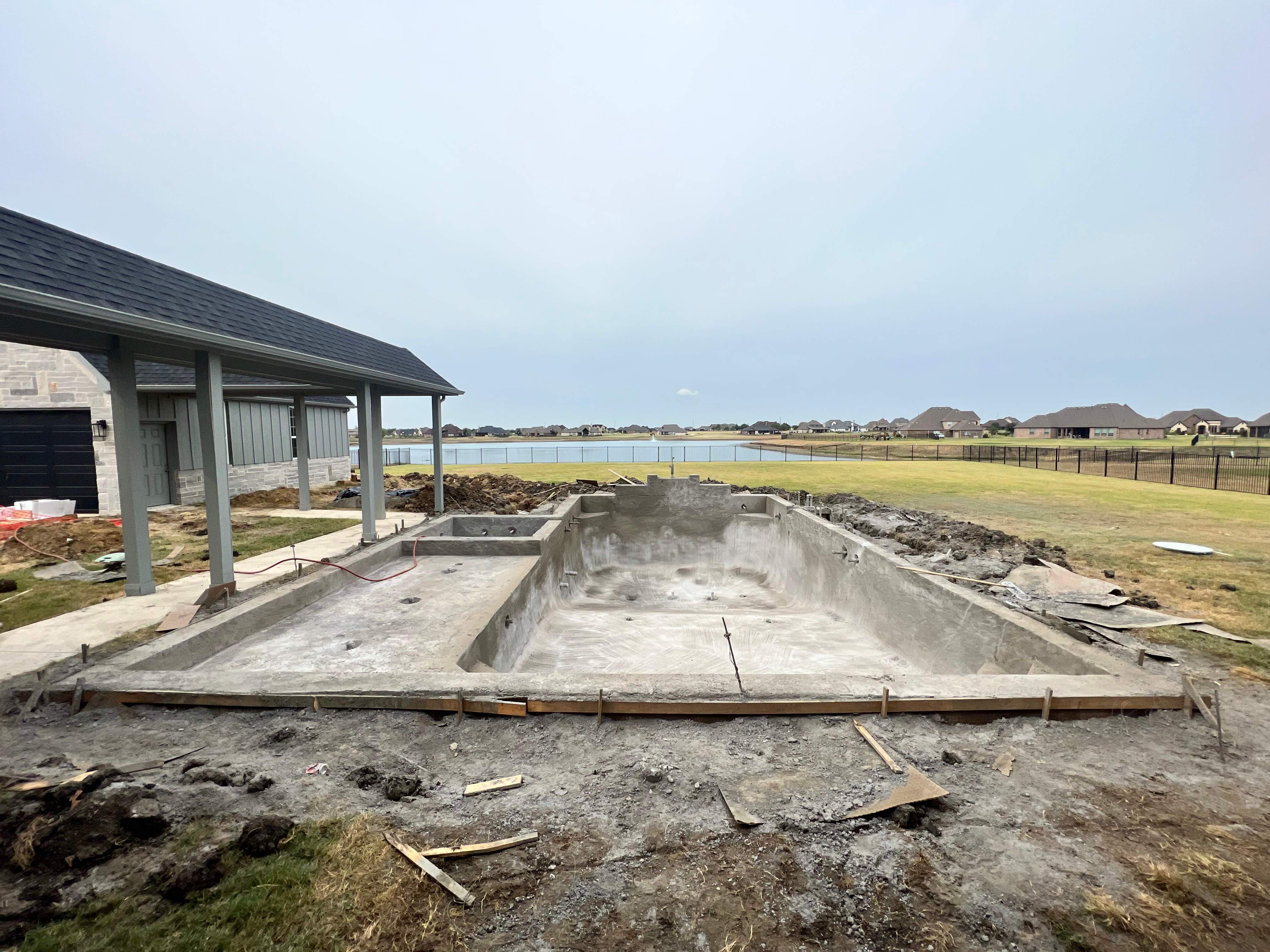Modern Lakefront Pool with Raised Spa and Dark Interior by Pinnacle Pools and Spas - DFW