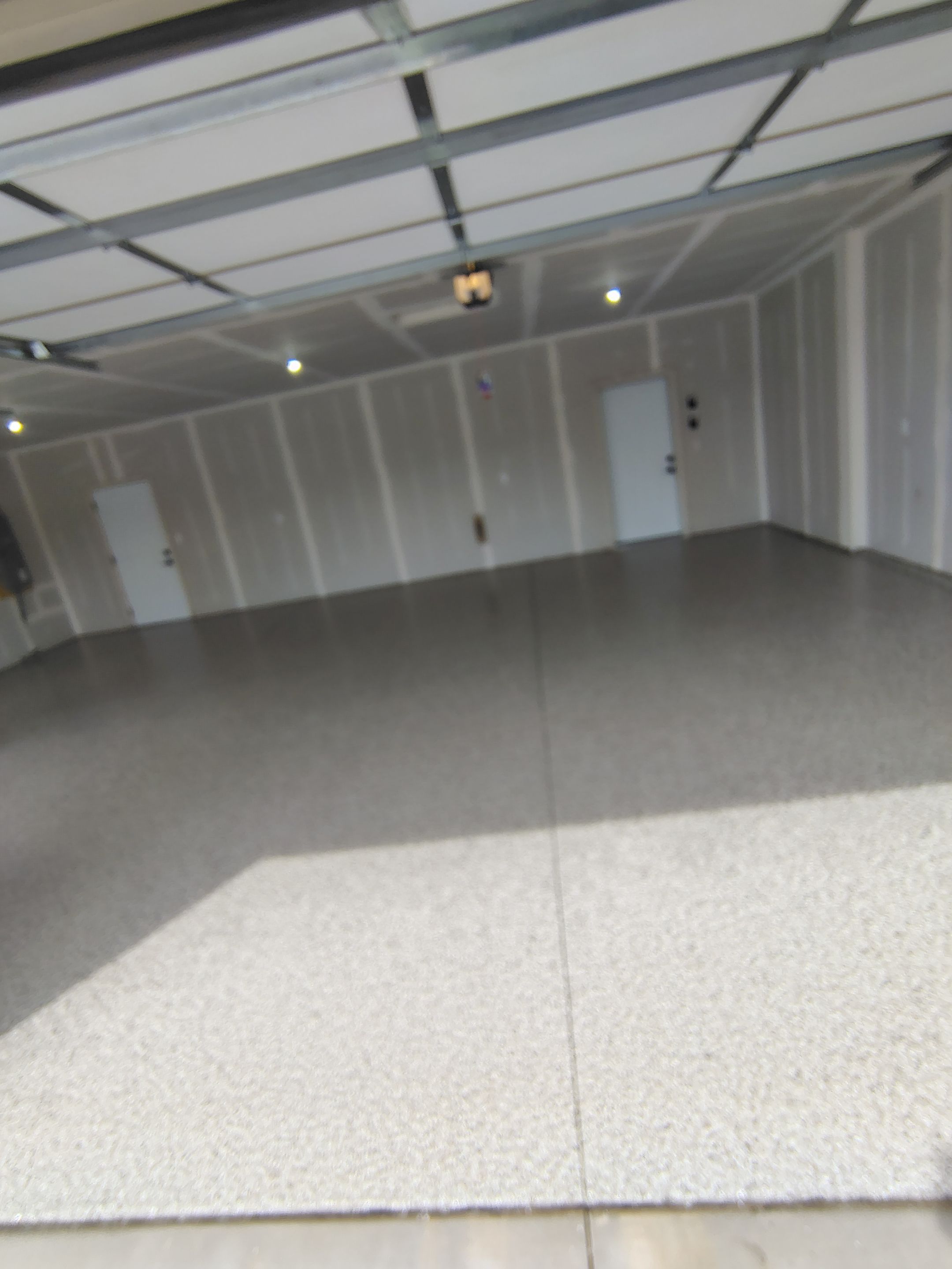 Speckled Epoxy Garage Floor Coating Installation in Sioux Falls by Select Painting, Coatings & Garage Cabinets