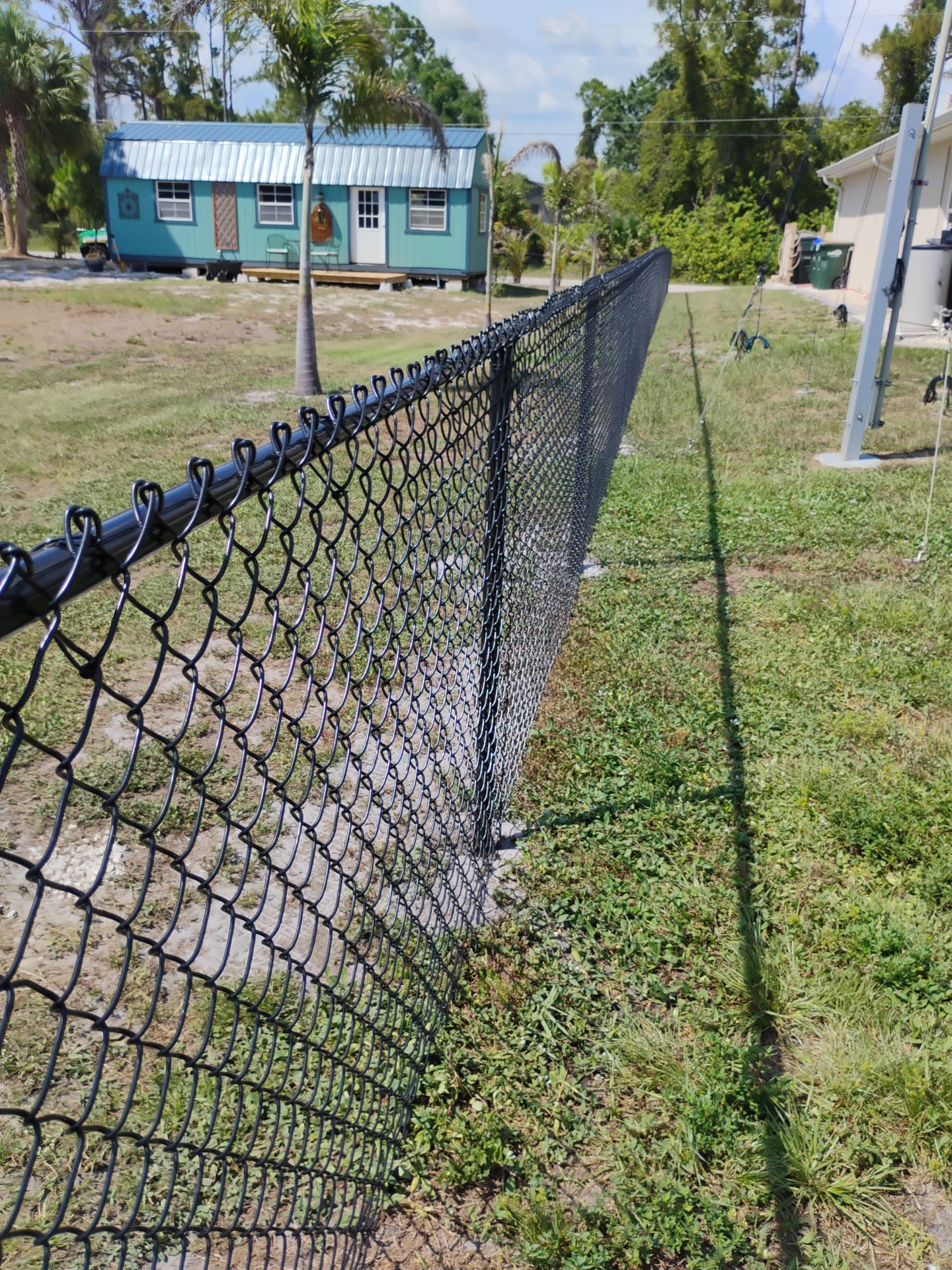 Black Vinyl-Coated Chain Link Fence and Rolling Gate Installation in North Port by True Fence LLC