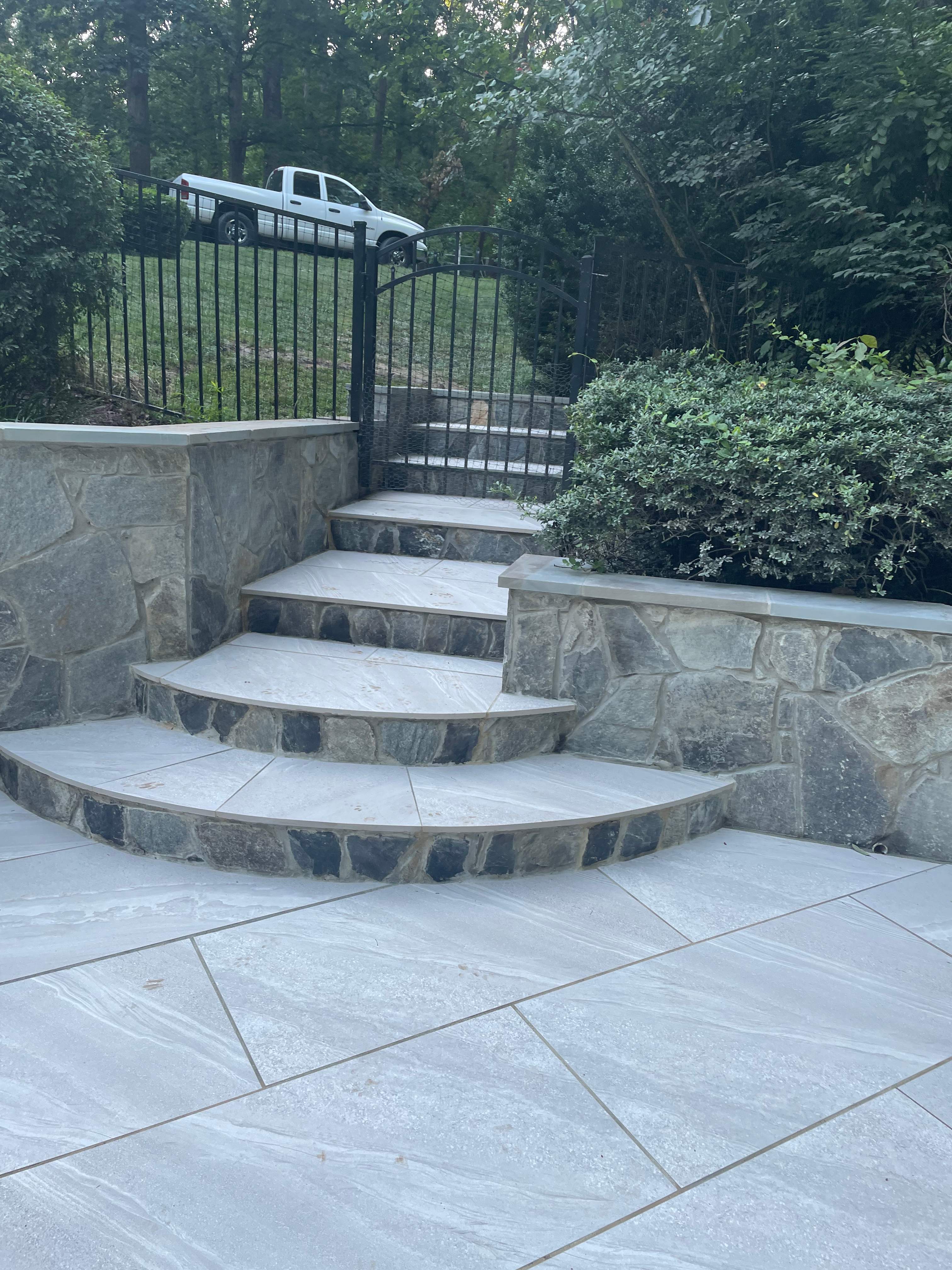 Pool Surround remodel with retaining walls, new waterfall and water slide by Fairfax Contractors, LLC