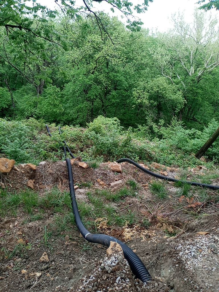 Supporting back of home with backfill at edge of steep creek by LAND ESCAPES LLC