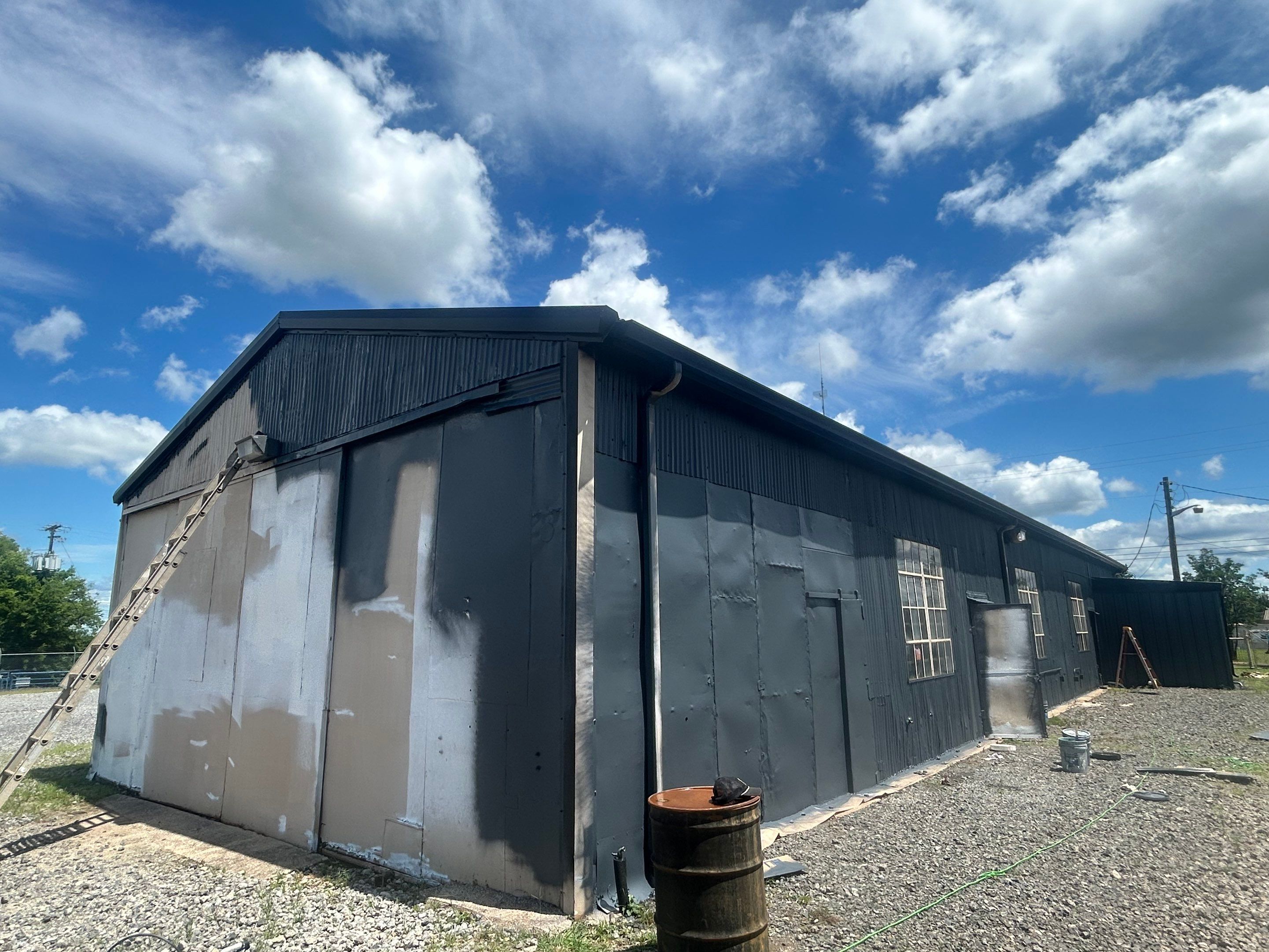 Exterior Painting in Kilgore, TX | Metal Building Transformation from White to Grey by Quality Coats Painting