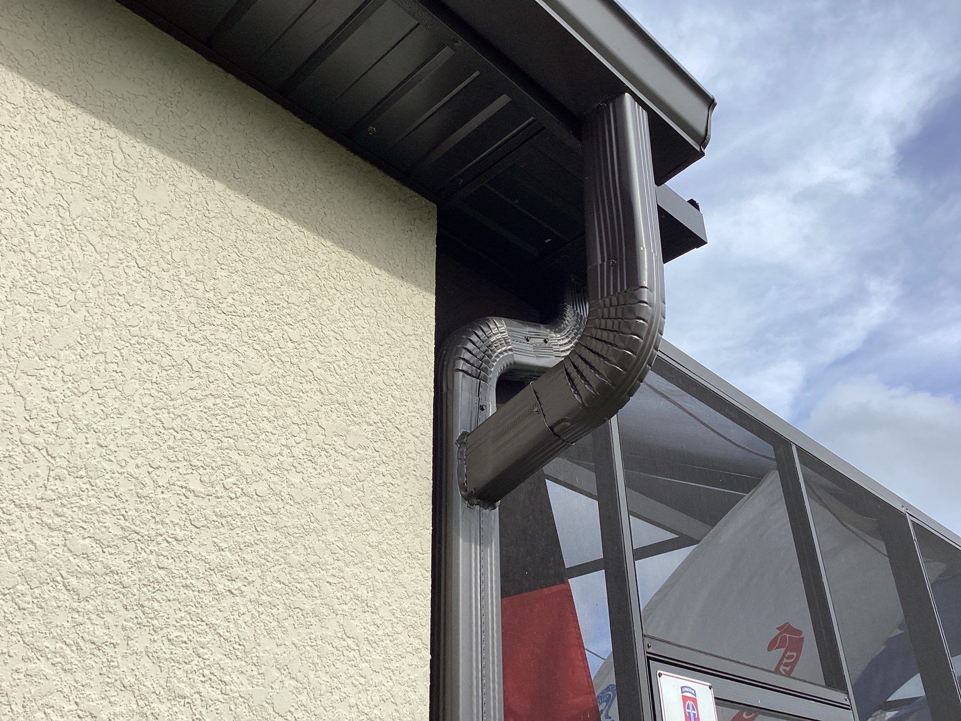 Musket brown seamless gutters with splash guards, new downspouts, and extensions in Bradenton, FL by Gutter Professors