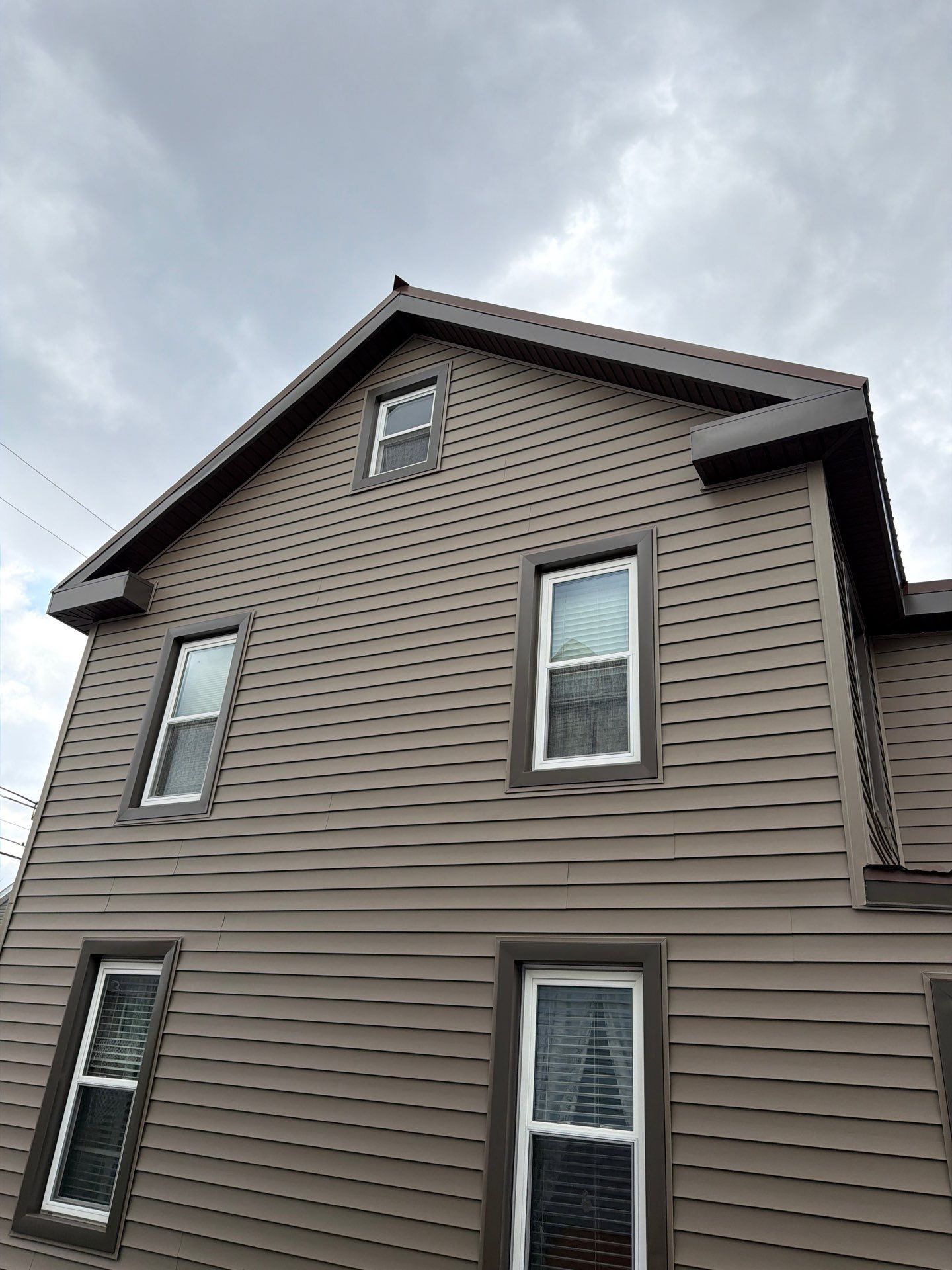 Exterior Renovation with Vinyl Siding, Metal Roof & Spouting  by Esh Builders