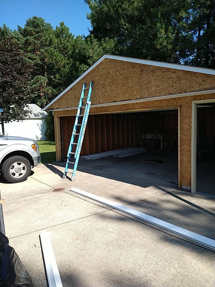 Siding Installation using Norandex woodsman dl-5 white woodgrain vinyl by Absolute Roofing and Construction