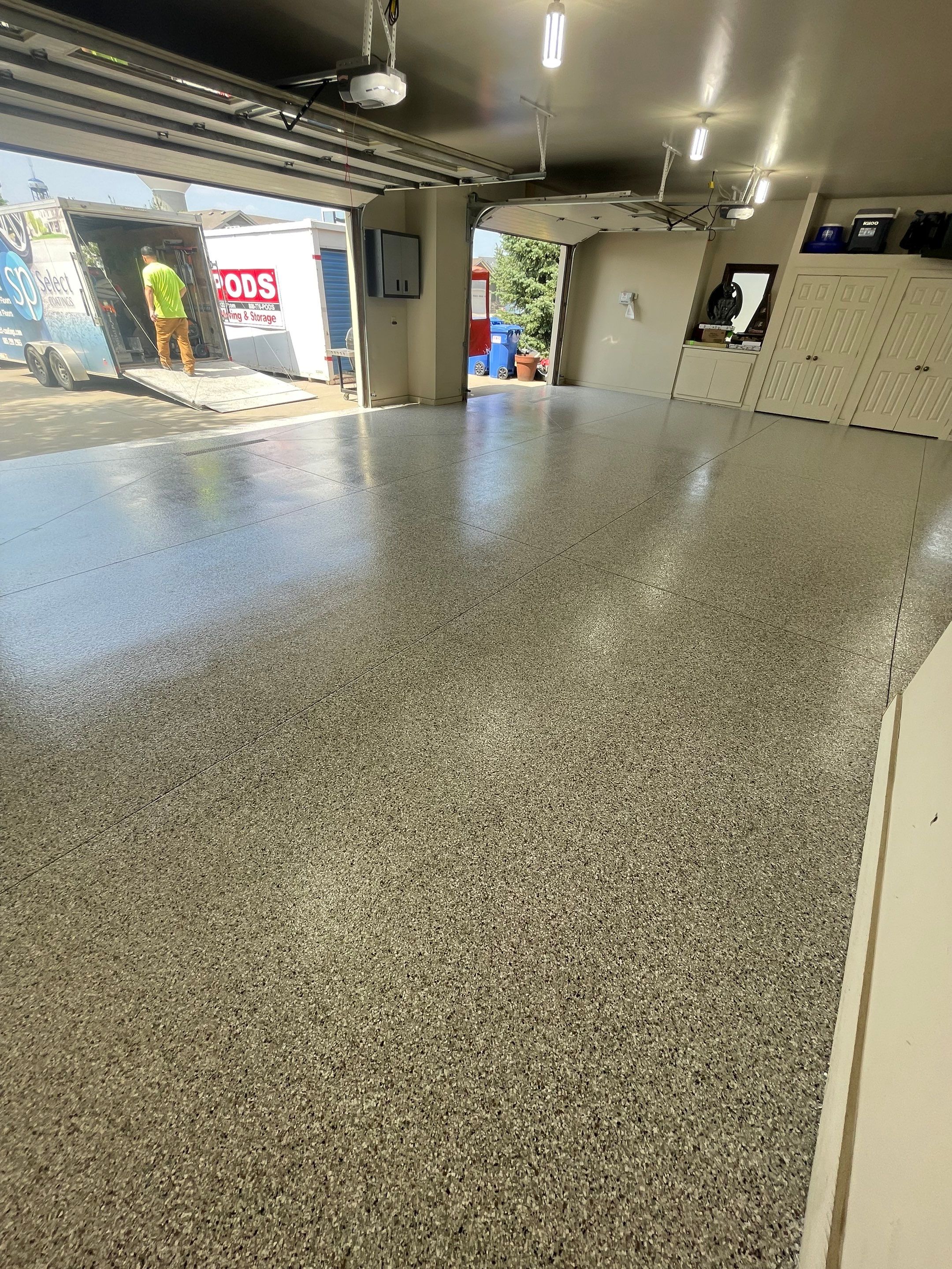 Coyote Flake Garage Floor Coating in Sioux Falls with Trench Drain by Select Painting, Coatings & Garage Cabinets