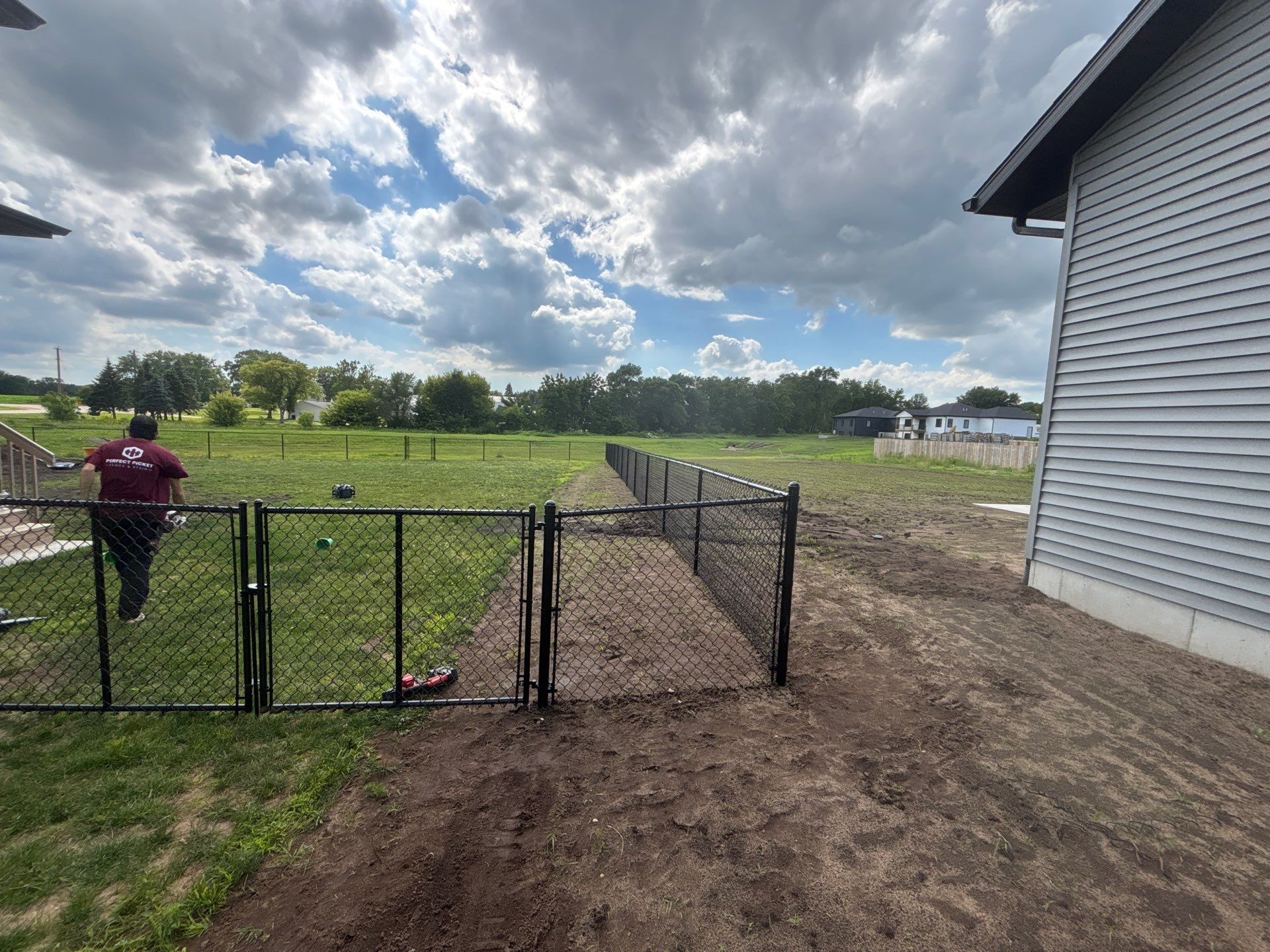 Black Vinyl-Coated Chain Link Fence and Residential Site Grading by Perfect Picket Fence and Stain