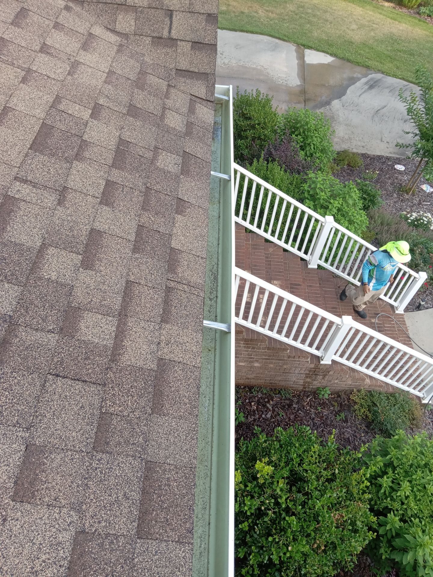 pressure washing company cleaning house exterior surfaces including roof and deck using high-pressure water spray