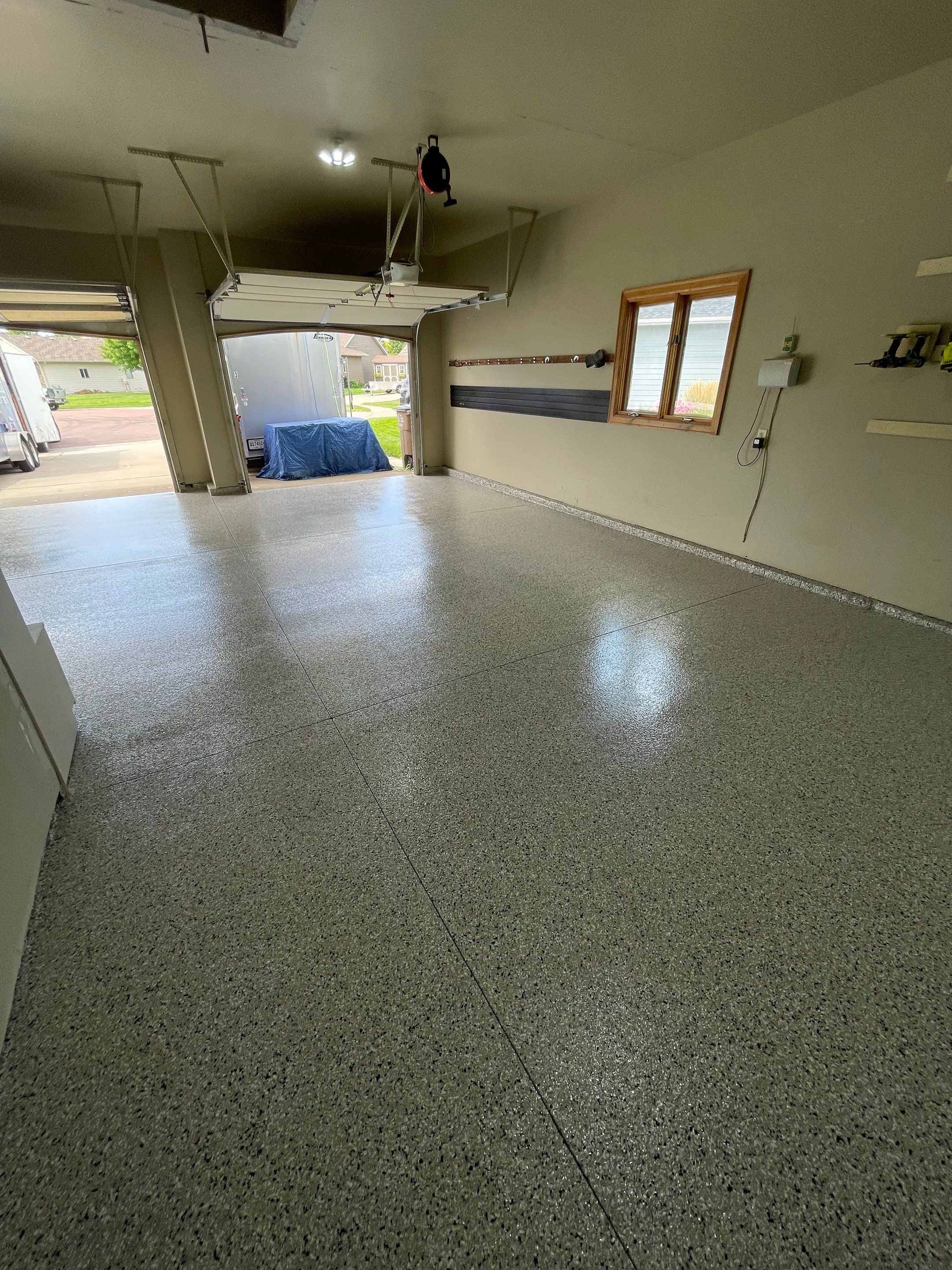 Cabin FEver Flake Garage Floor Coating Installation in Sioux Falls by Select Painting, Coatings & Garage Cabinets