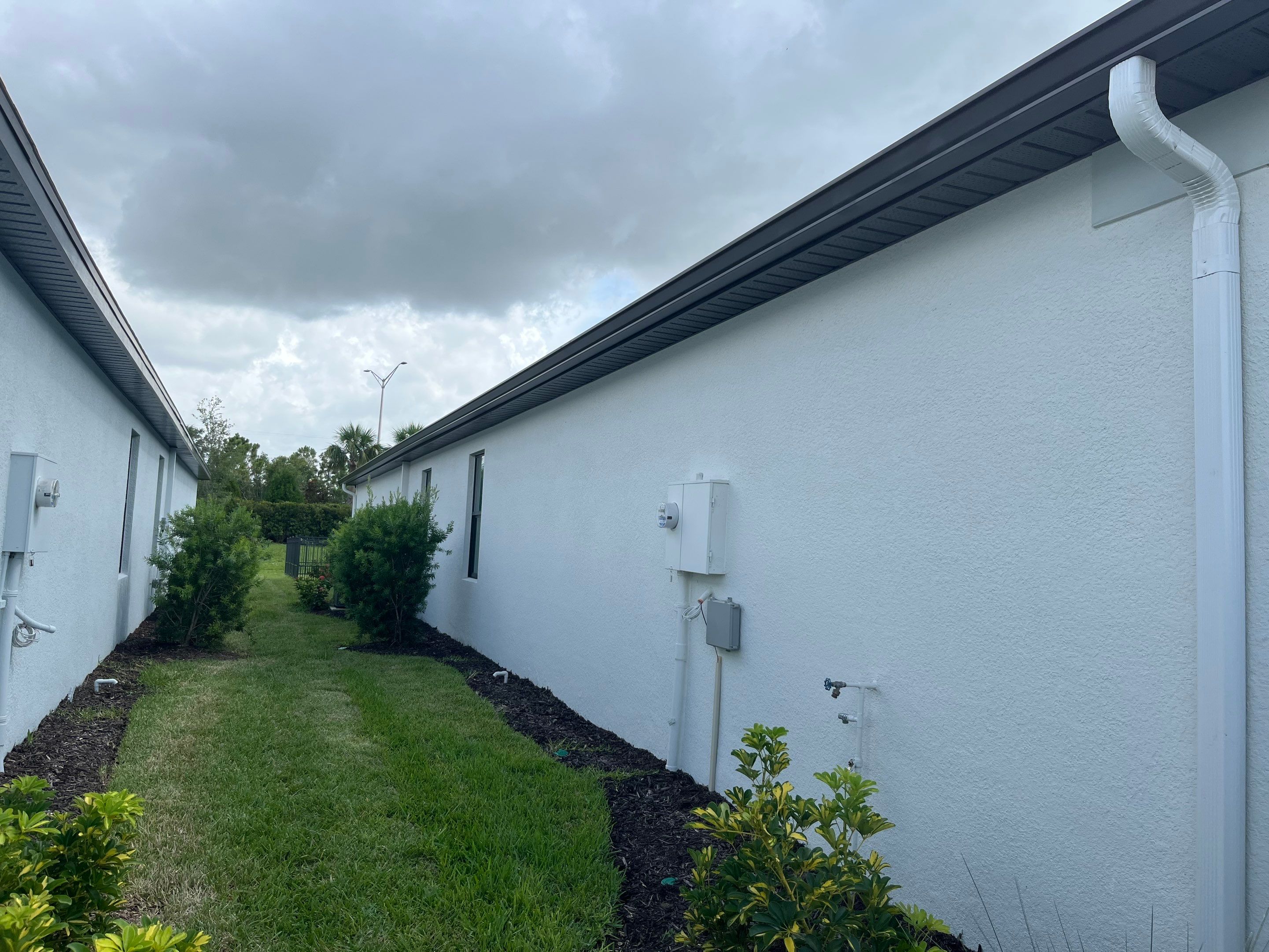 Dark Bronze Gutters and White Downspouts in Sarasota FL by Gutter Professors