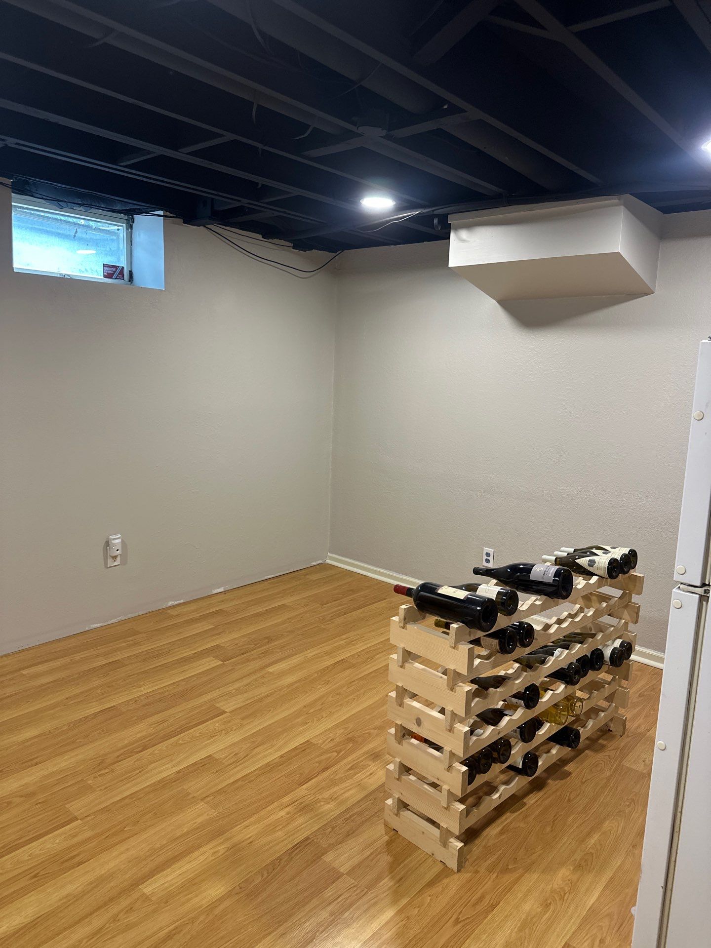 Basement Remodel with Exposed Painted Ceilings and Laminate Flooring in Mequon by OCS Contracting Services