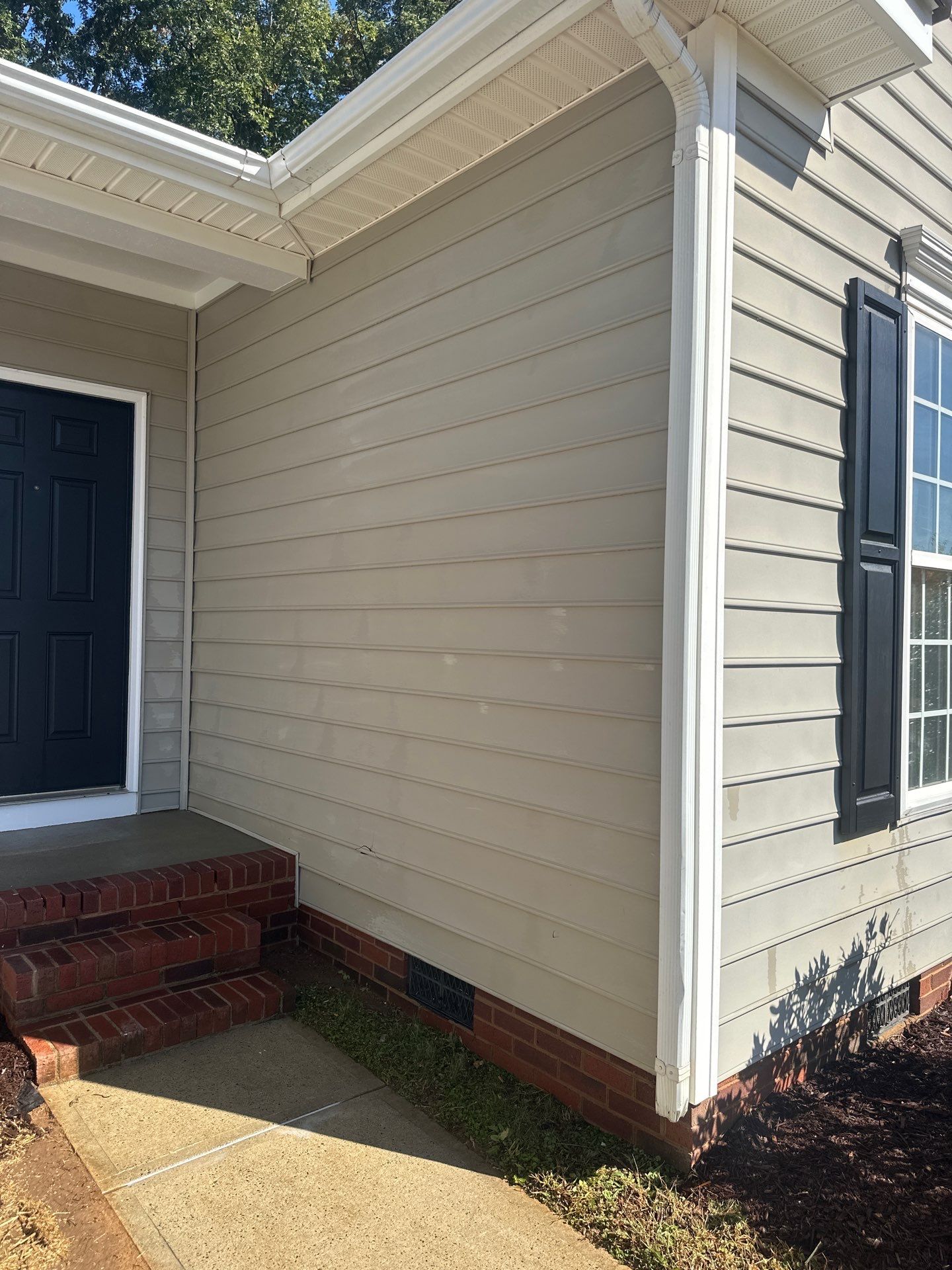 the service being done is cleaning the vinyl siding and brick steps to remove dirt and grime for a refreshed appearance