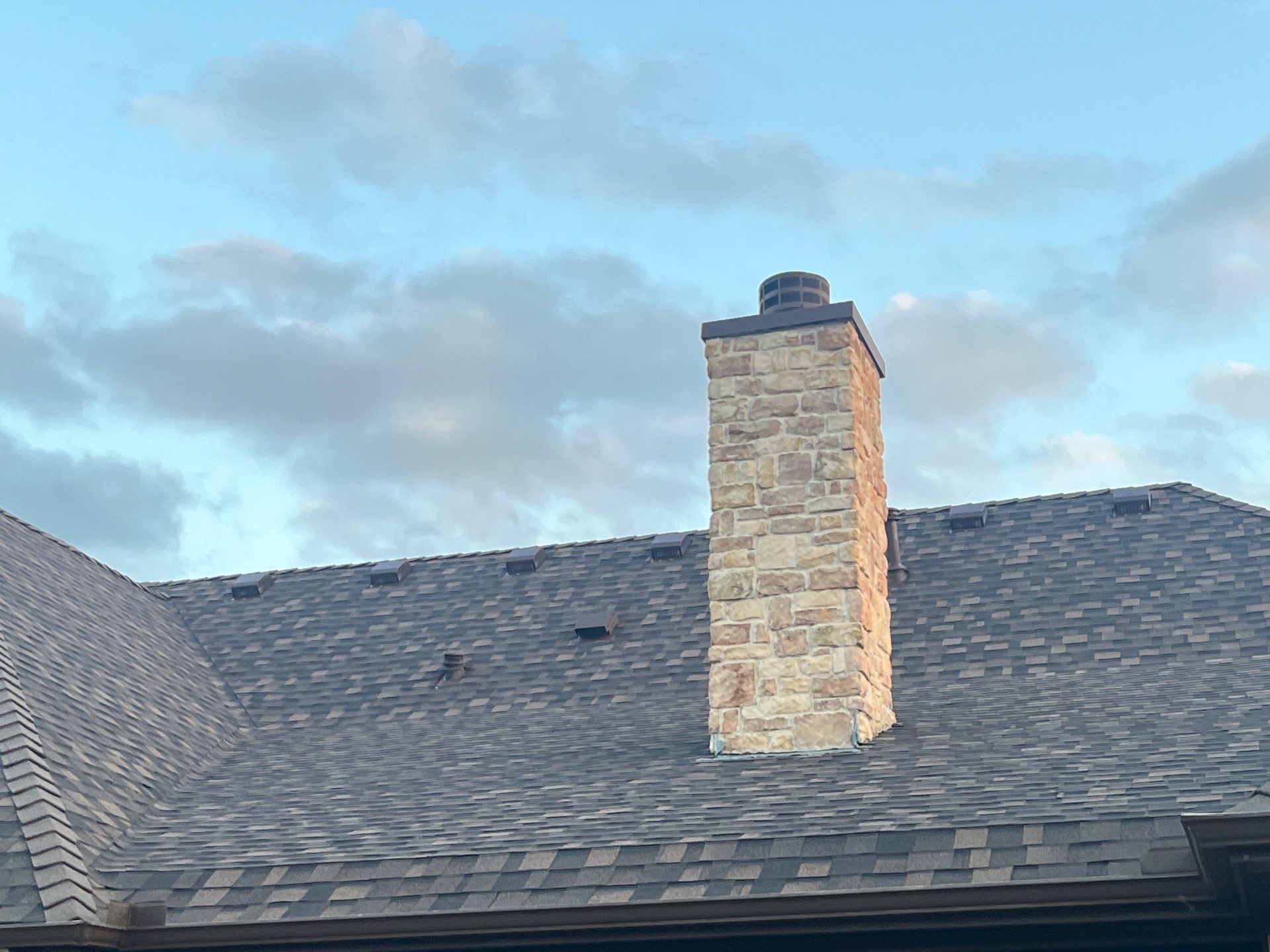 Cream brick/mixed stone with IKO Shadow Brown by Tejas Roofworks + Restoration